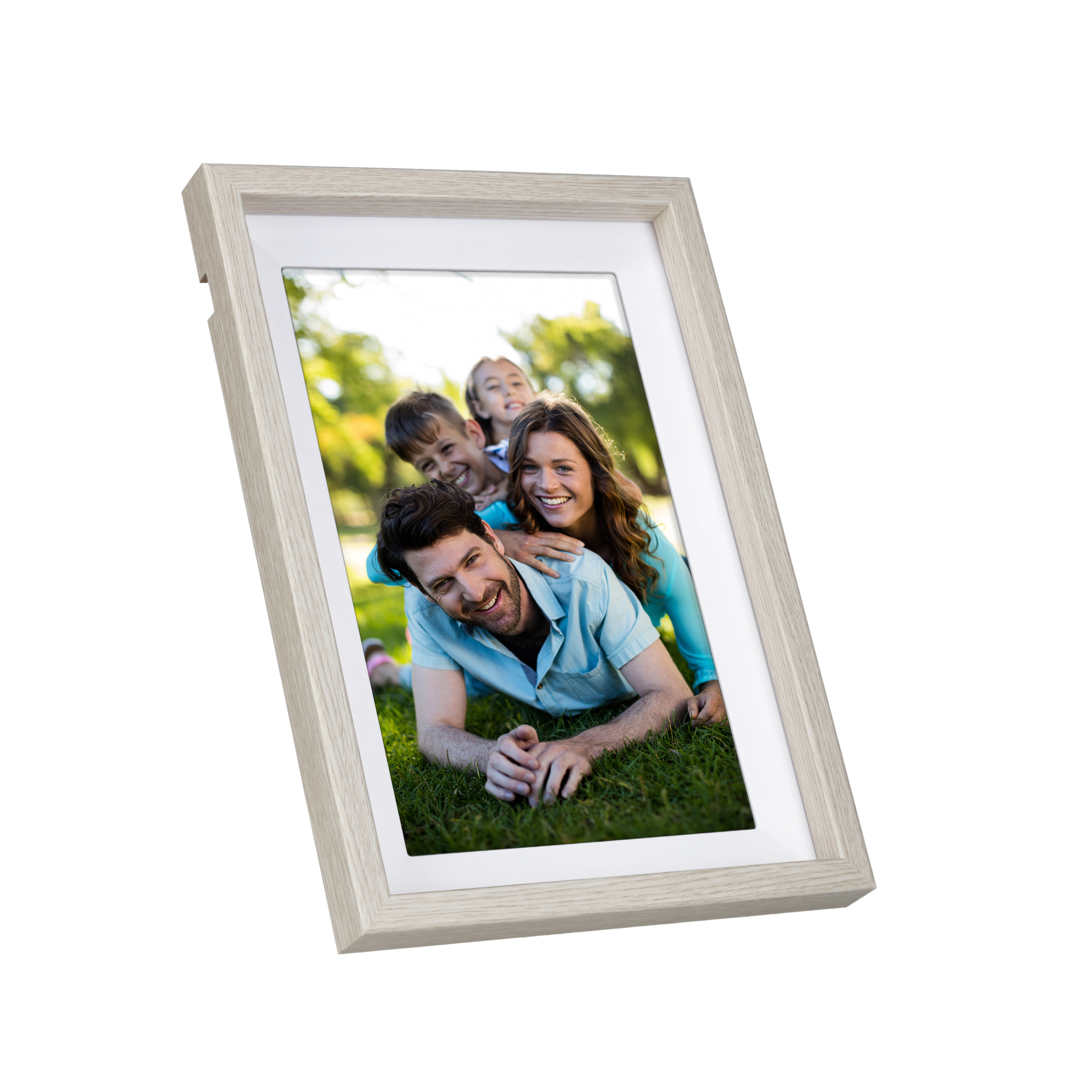 Ein gerahmtes Familienfoto zeigt Eltern und zwei Kinder, die auf Gras in einem Park lächeln. Der Rahmen ist helles Holz.