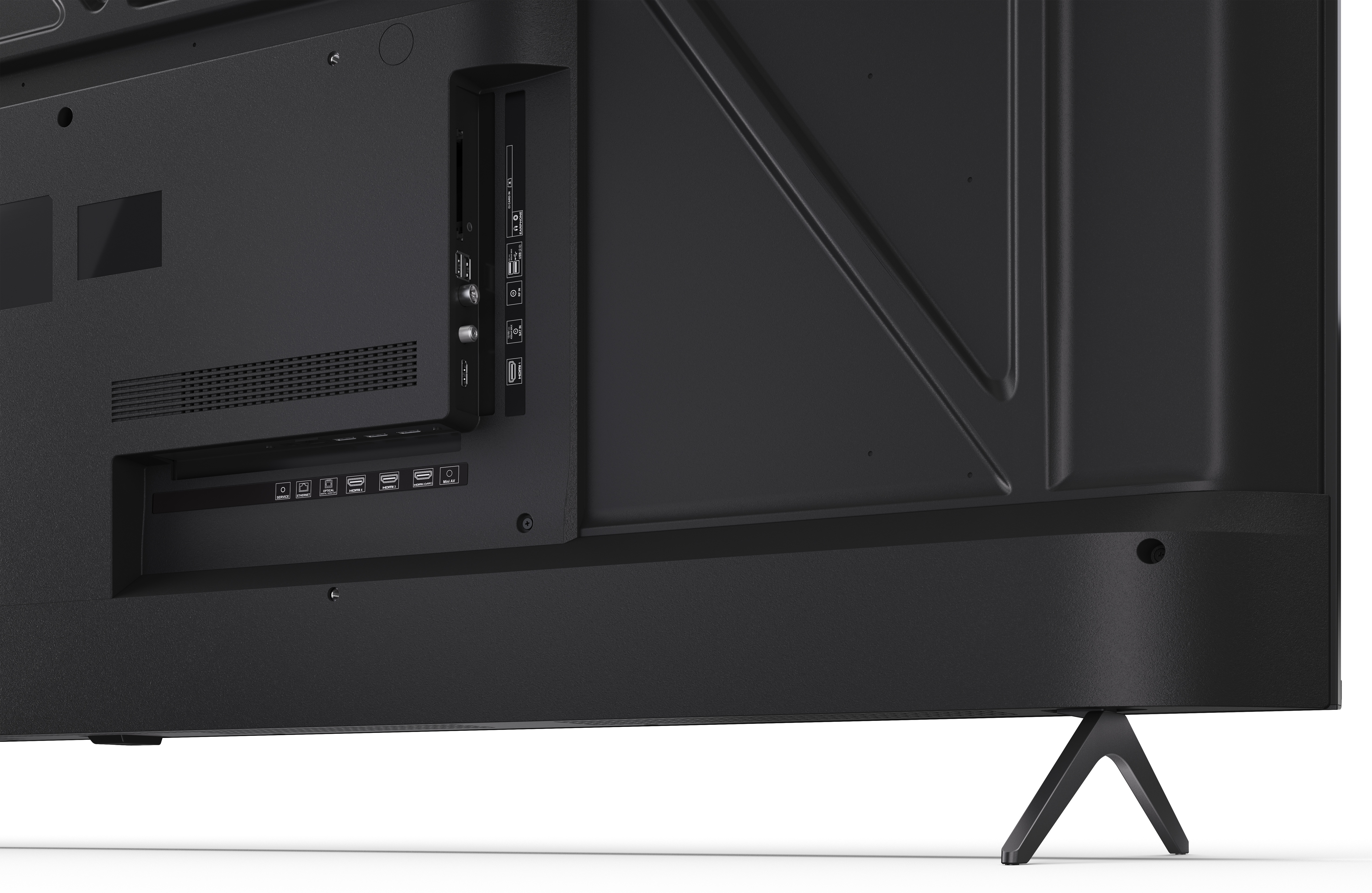 Tył czarnego telewizora z portami, wentylacją i stojakiem. Telewizor stoi na białej powierzchni.