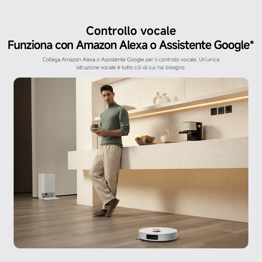 Uomo in cucina con caffè, robot che aspira. La cucina ha una macchina per il caffè, frutta e un altoparlante intelligente.