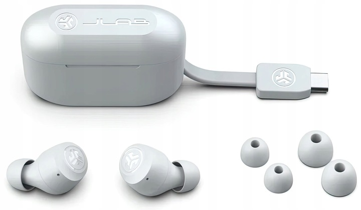 Białe słuchawki JLab, etui ładujące i kabel USB-C na białej powierzchni. W zestawie zapasowe wkładki.