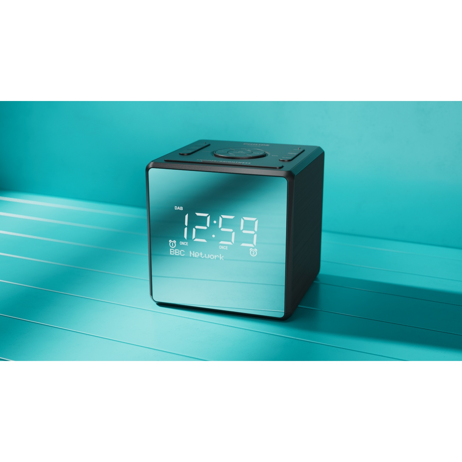 Un orologio digitale nero e verde acqua segna le 12:59. Ha la forma di un cubo ed è appoggiato su una superficie verde acqua. Lo sfondo è verde acqua.