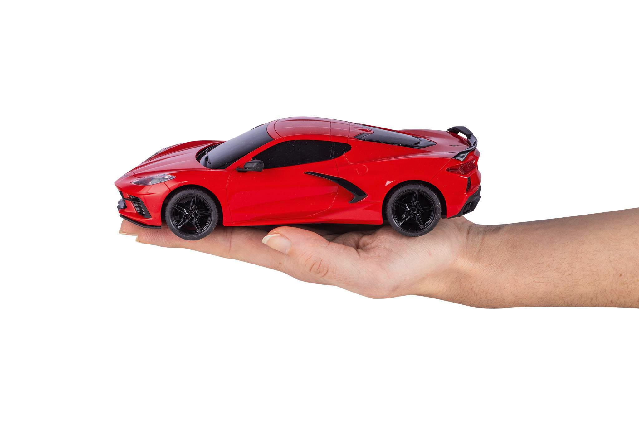 Ein rotes Spielzeugauto wird in einer Hand gehalten. Das Auto ist ein Sportwagen mit schwarzen Rädern und einem schwarzen Spoiler. Der Hintergrund ist weiß.