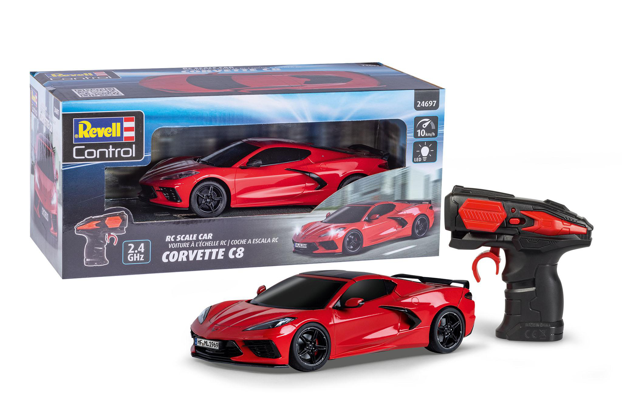 Ein rotes Corvette C8 Modellauto, eine Schachtel und eine Fernbedienung werden angezeigt. Das Auto hat schwarze Räder und steht vor der Box.