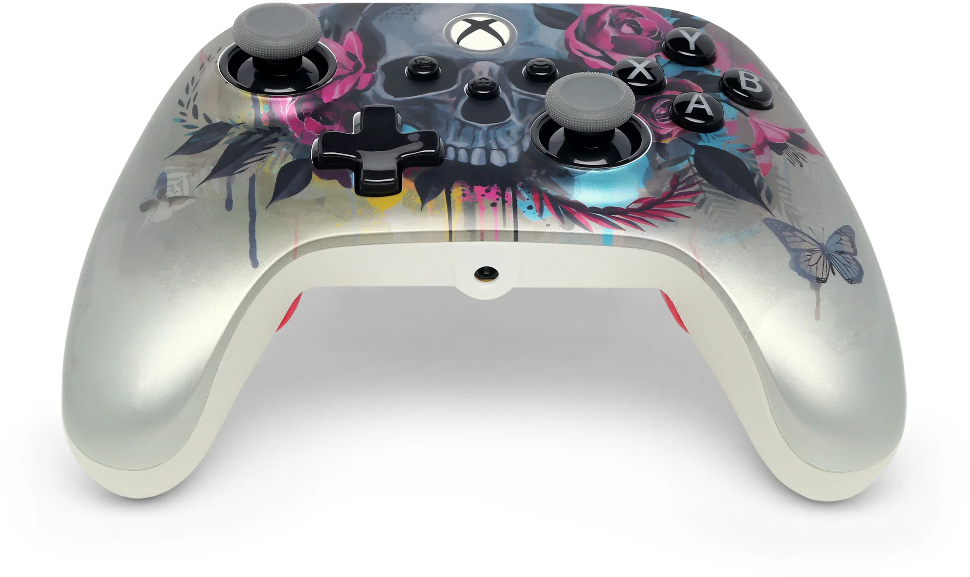 Xbox-vezérlő virágos és koponya dizájnnal. A színek a szürkét, rózsaszínt és feketét foglalják magukban. A gombokon betűk és szimbólumok vannak.