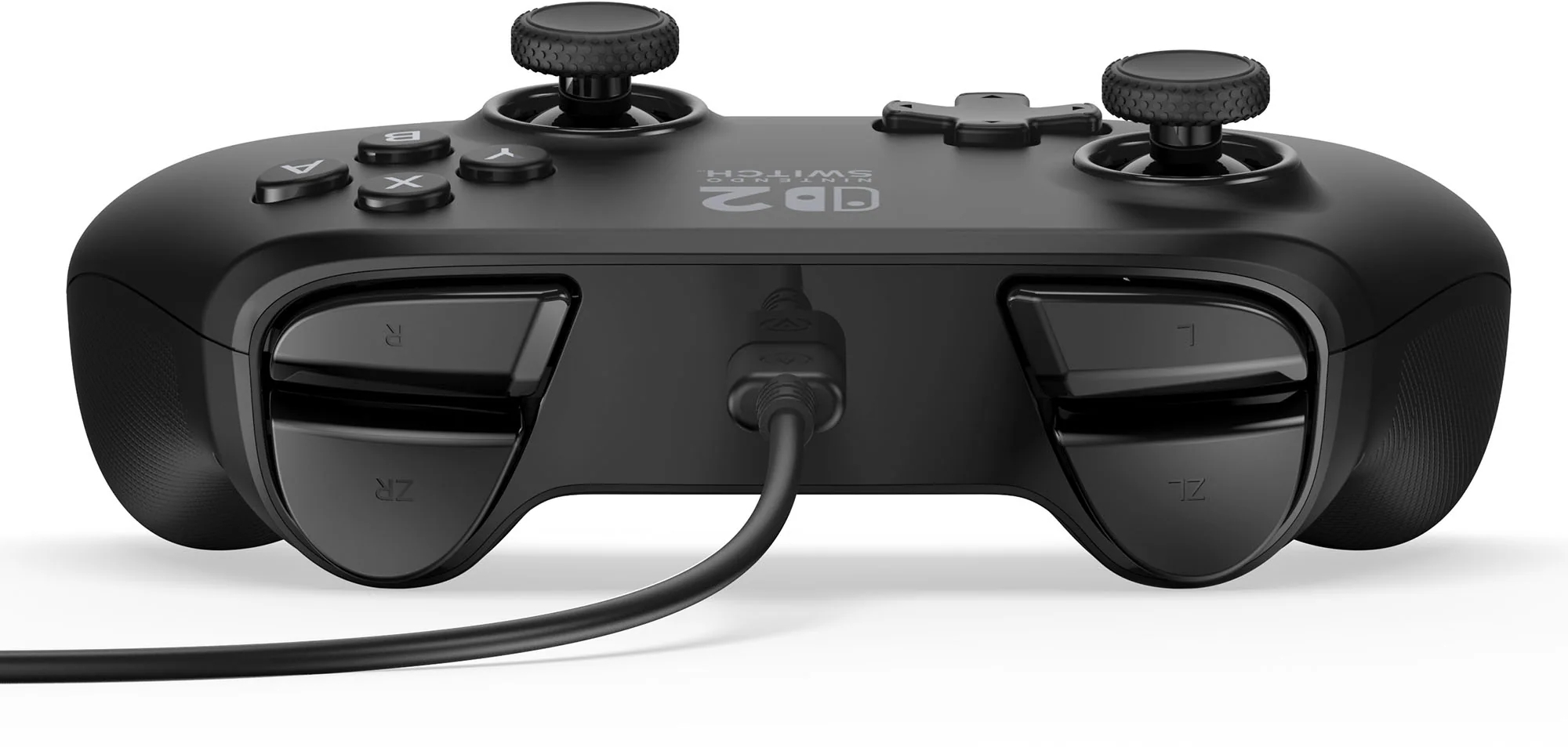 Egy fekete Nintendo Switch kontroller gombokkal, joystickokkal és ravaszokkal. Egy töltőkábel van bedugva.