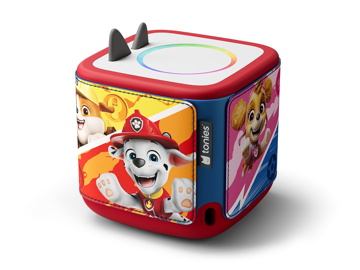 Un Toniebox Paw Patrol. È rosso, blu e bianco, con immagini di Marshall, Skye e altri personaggi di Paw Patrol.