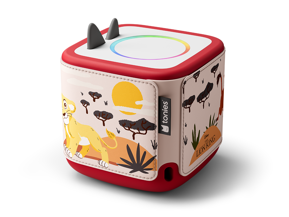 Un cube rouge et blanc avec un design du Roi Lion. Il y a un lion, des arbres et un soleil. Le dessus a un anneau lumineux et deux petites cornes.
