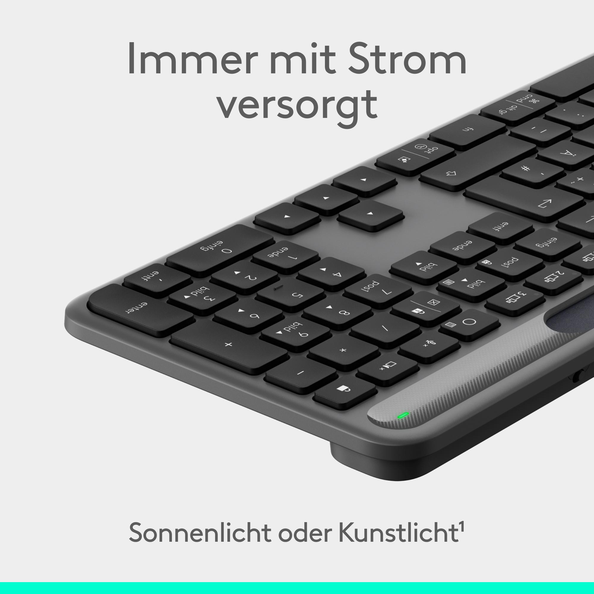 Nahaufnahme einer schwarzen Computertastatur mit weißem Text, auf hellgrauem Hintergrund. Der Text ist auf Deutsch.
