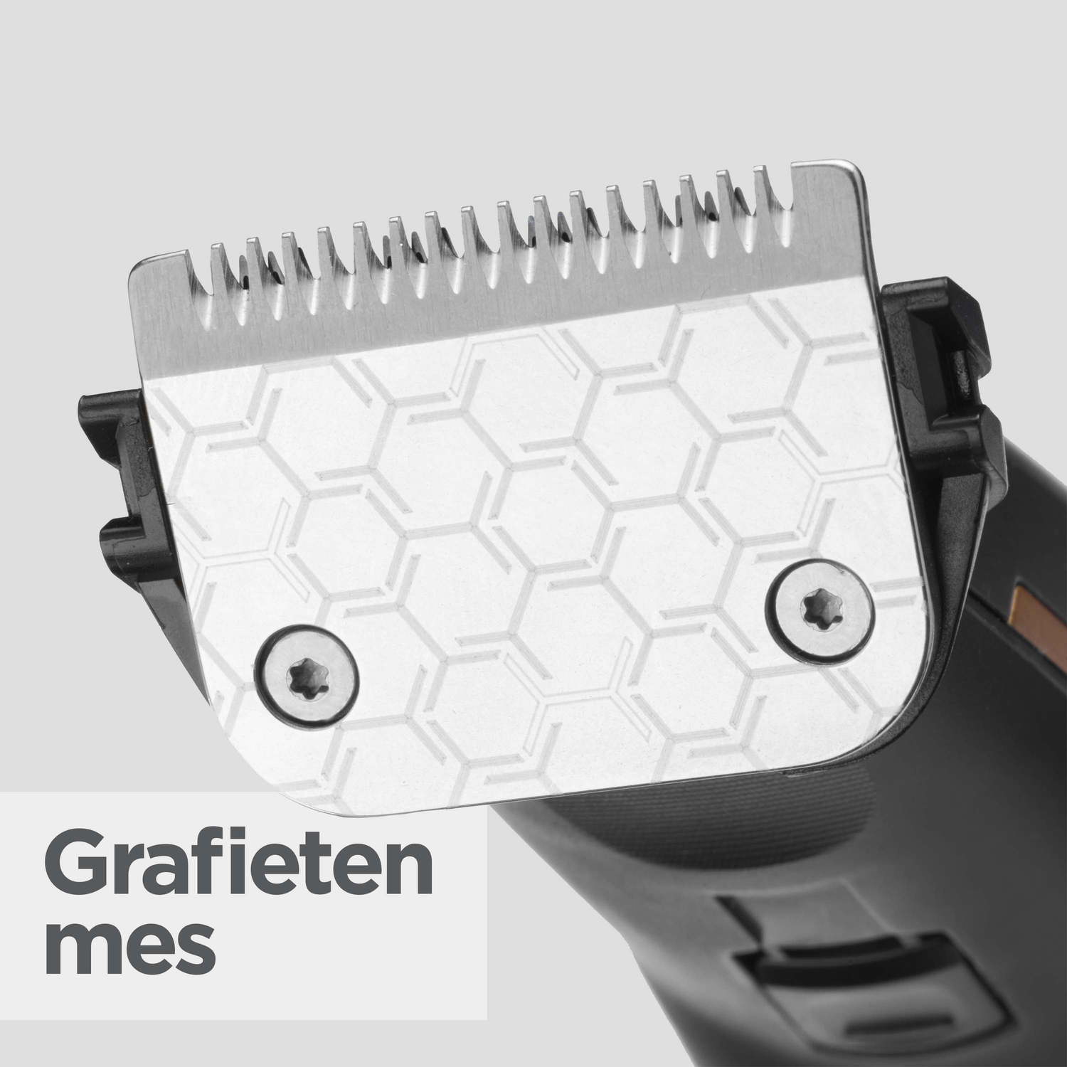 Close-up of a shaver blade. The metal blade has teeth and a honeycomb pattern. The shaver handle is black.