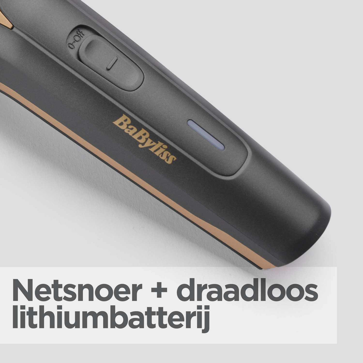 Close-up of a black and gold Babyliss trimmer. It has an on/off button and a charging indicator. Dutch text at the bottom.