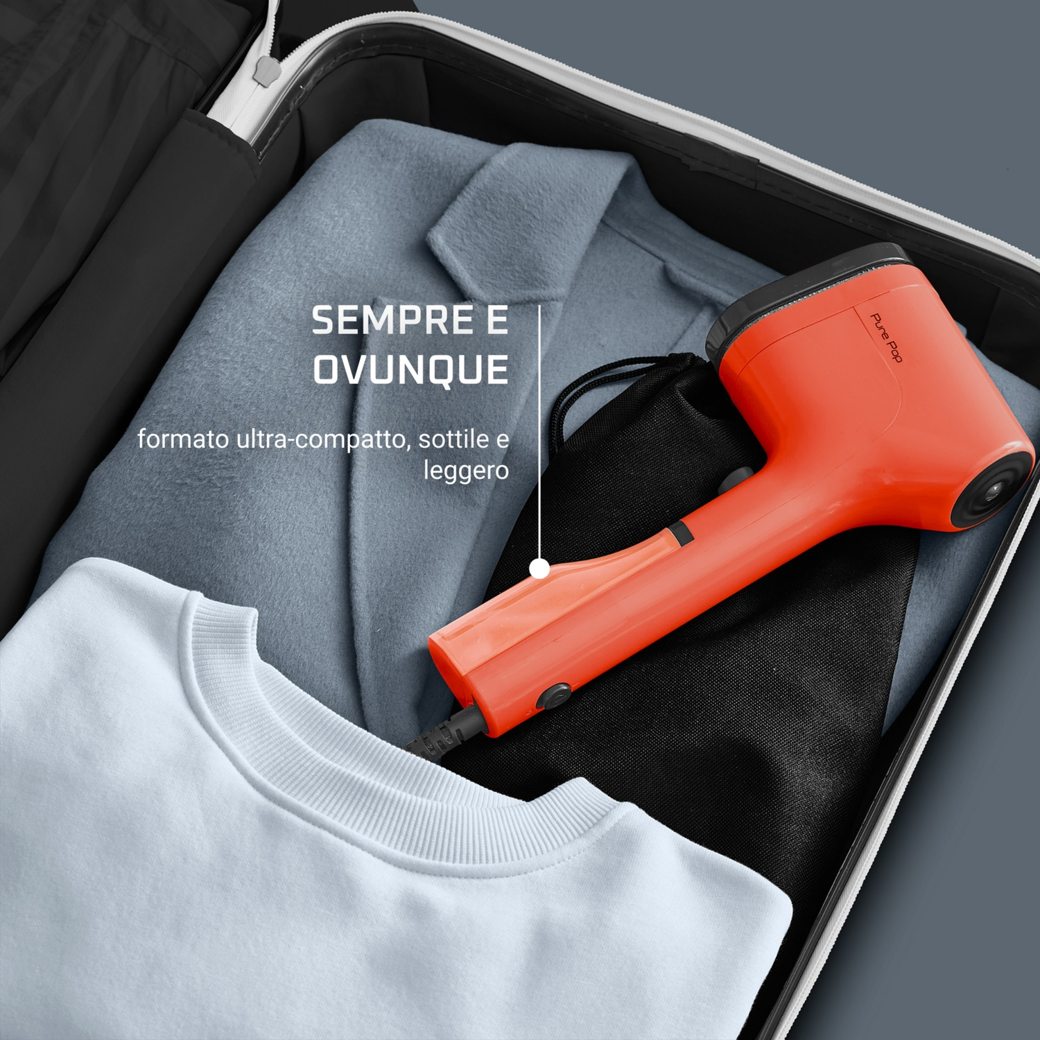 Una valigia aperta con vestiti e un vaporizzatore Pure Pop arancione. Include un cappotto azzurro, un maglione bianco e una borsa nera.