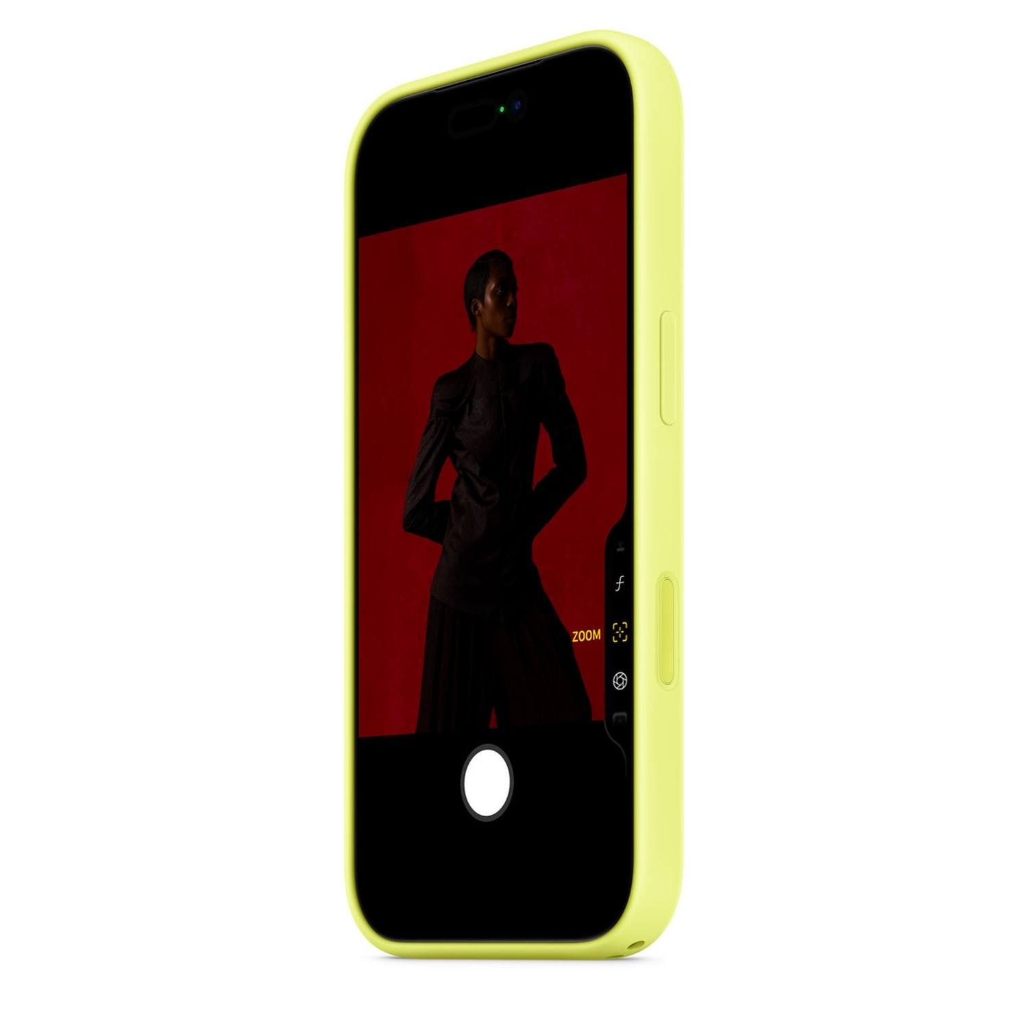 Un téléphone dans un étui vert affiche une photo d'une personne en noir sur fond rouge, avec une interface d'appareil photo.