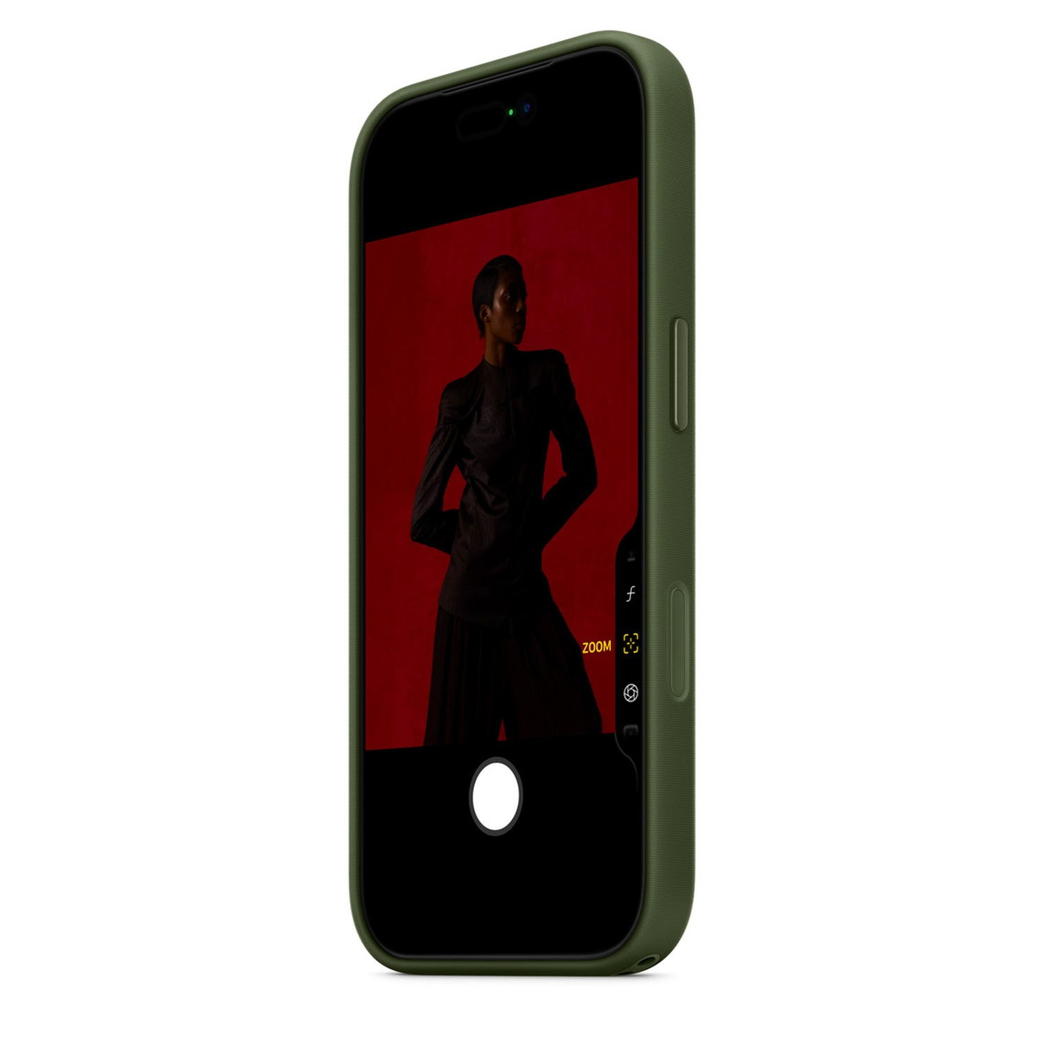 Un téléphone affiche une personne vêtue de sombre sur fond rouge. Le téléphone a une coque verte et l'appareil photo est actif.