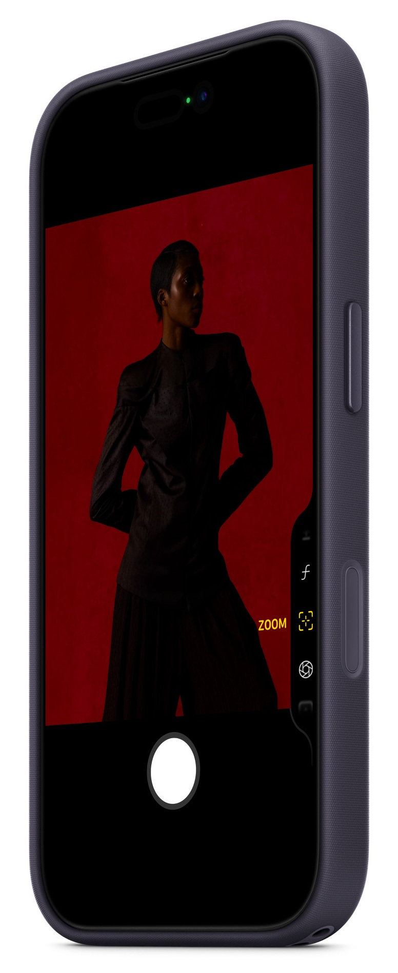 Telefon wyświetla zdjęcie osoby w ciemnym garniturze na czerwonym tle. Telefon jest w ciemnoniebieskim etui.