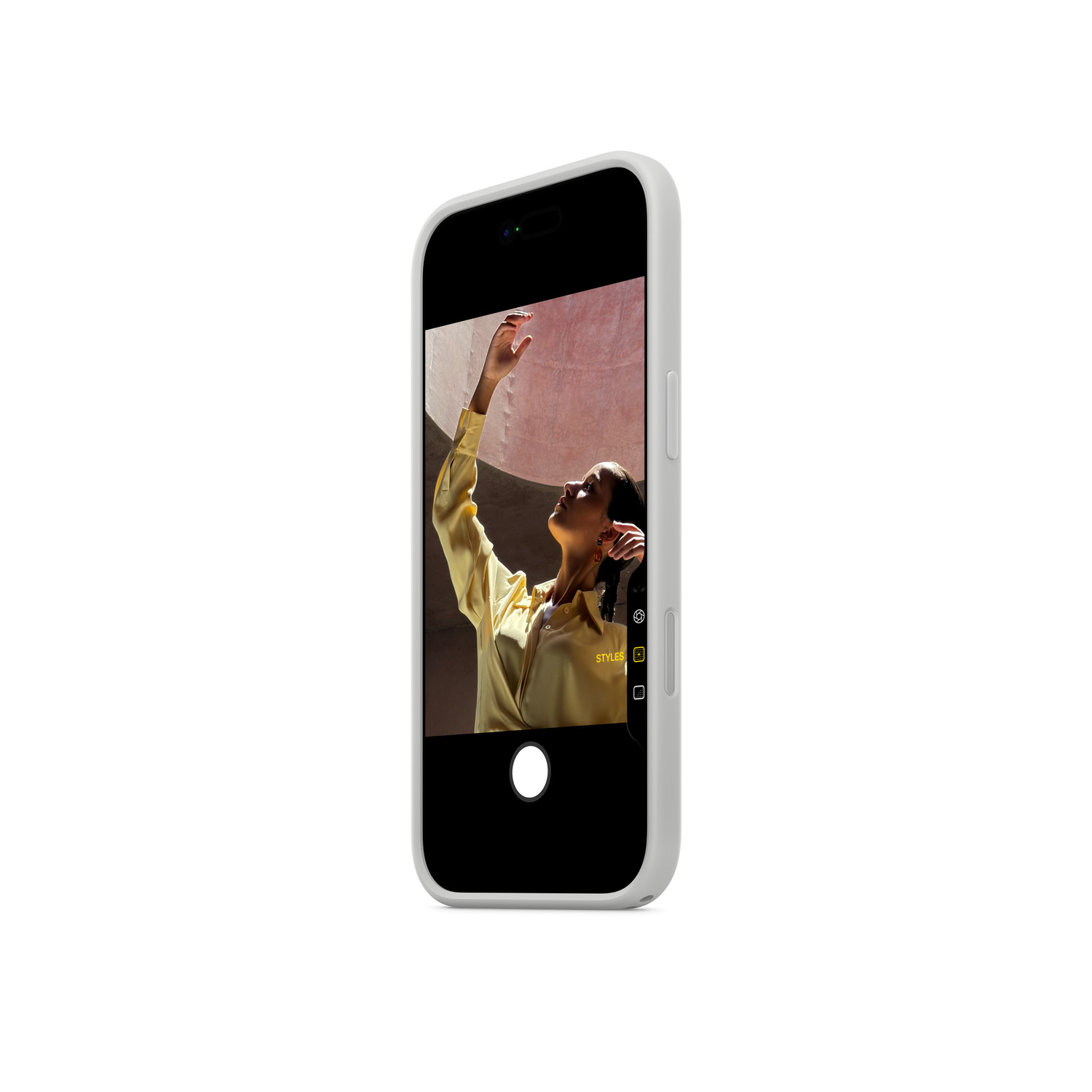 Een smartphone toont een vrouw in een gele blouse met haar arm omhoog. De telefoon heeft een witte hoes en staat tegen een witte achtergrond.