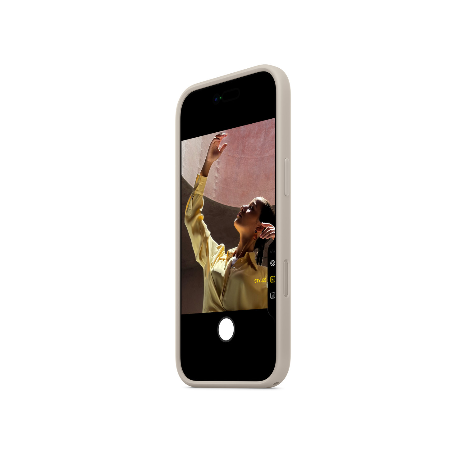 Un téléphone affiche une femme en chemise jaune, tendant le bras vers le haut. Le téléphone est dans un étui et le fond est blanc.