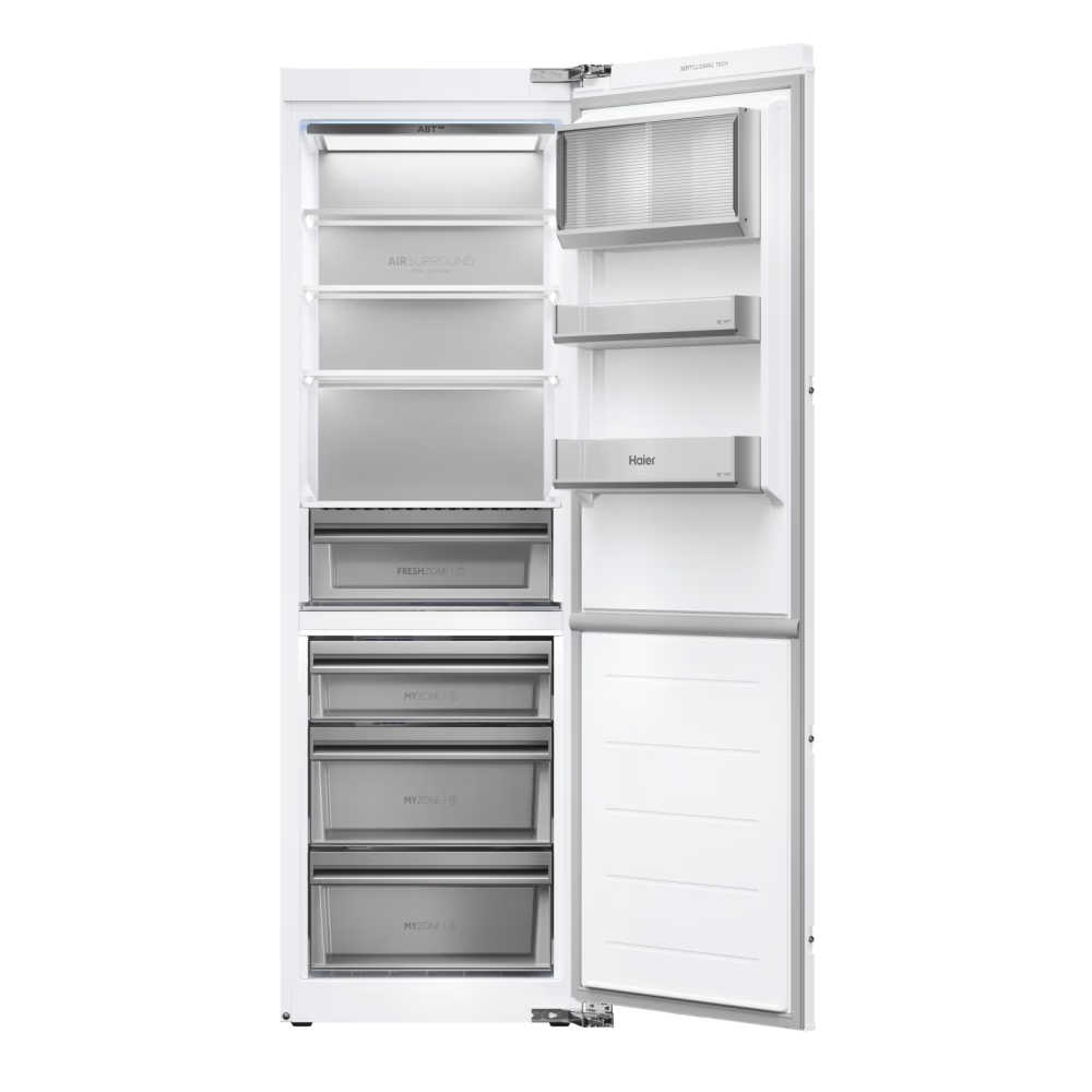 Egy fehér Haier hűtőszekrény nyitott ajtóval. Belül polcok, fiókok és rekeszek találhatók, olyan feliratokkal, mint a 'Fresh Zone'.