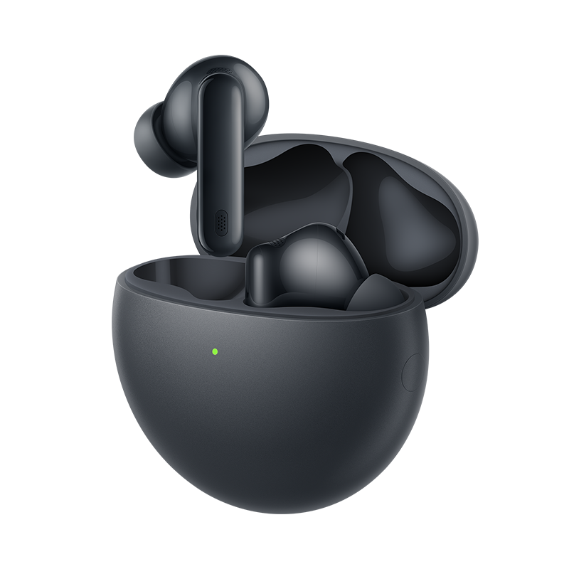 Primer plano de auriculares inalámbricos negros en un estuche de carga abierto. Un auricular está fuera. Una luz verde está encendida.