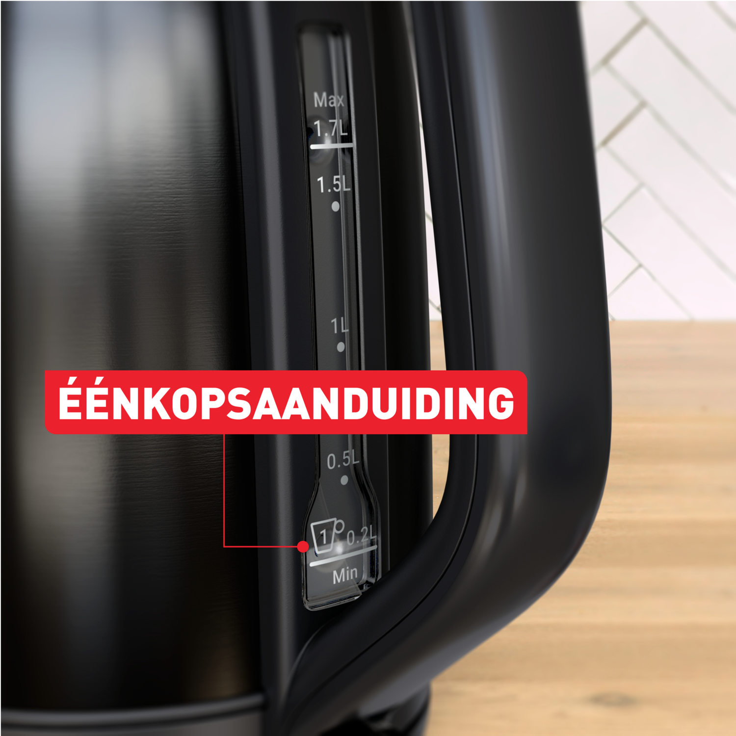 Black kettle with a water level indicator. It shows the max level and the minimum level for a single cup. Red text: 'Éénkopsaanduiding'.