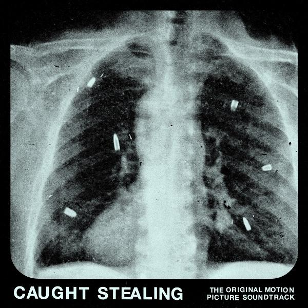 Röntgenaufnahme einer Brust mit Kugeln im Inneren. Das Bild stammt vom Soundtrack 'Caught Stealing'. Schwarzer Hintergrund.