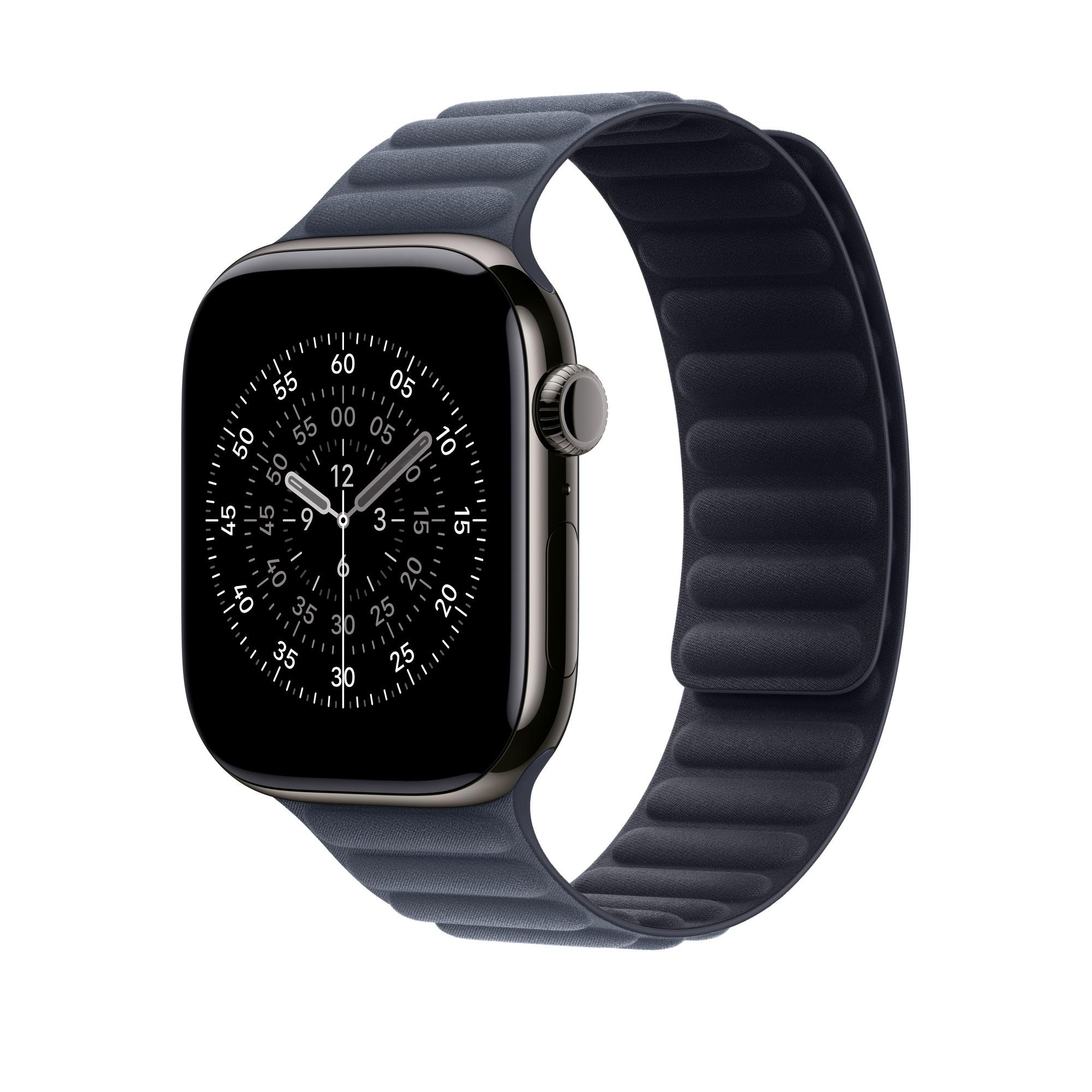 Eine dunkelgraue Apple Watch mit schwarzem Bildschirm und dunkelblauem Magnetarmband. Die Uhr zeigt die Uhrzeit.