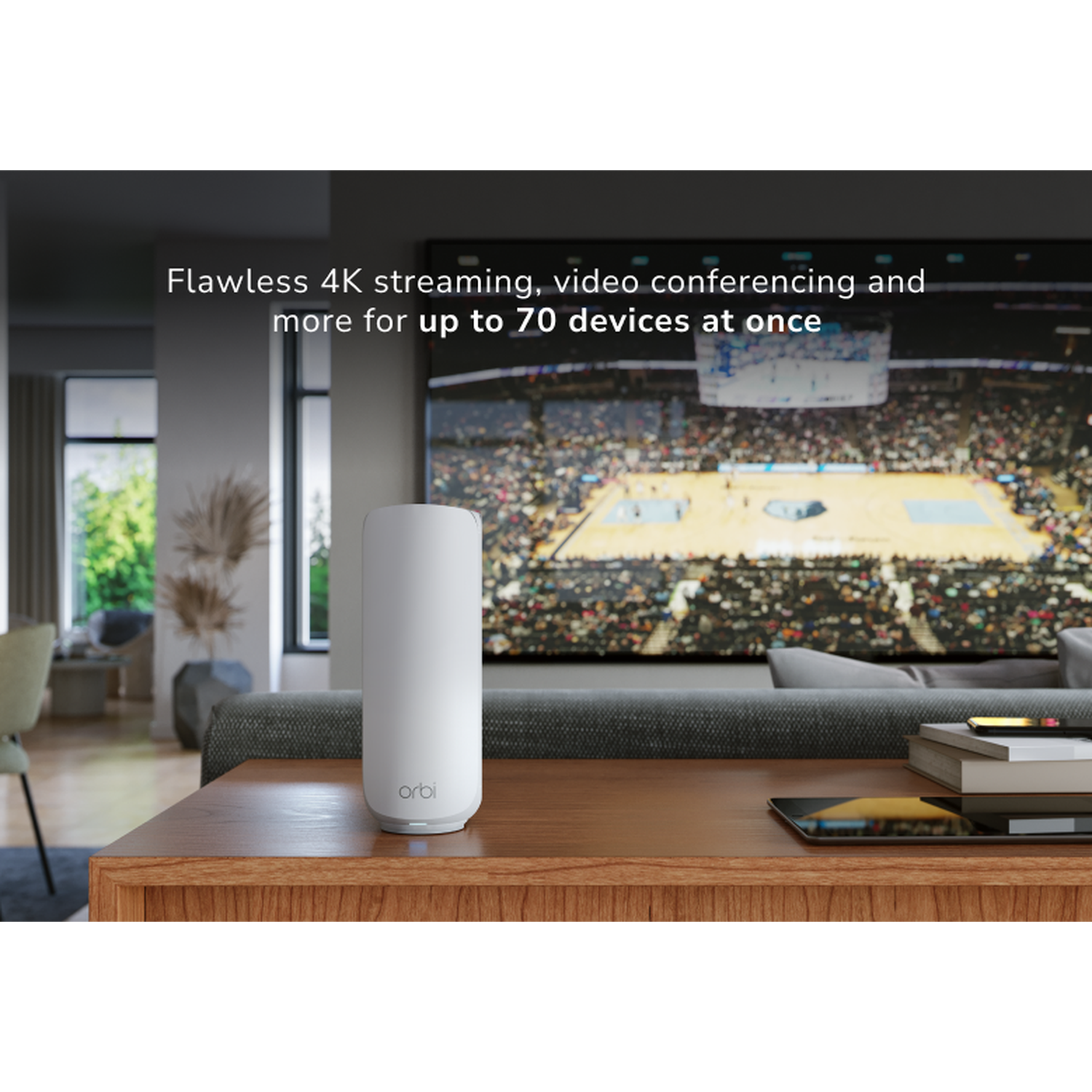 A white Orbi device sits on a wooden table. A large screen shows a sports event. The room has a sofa and chair.