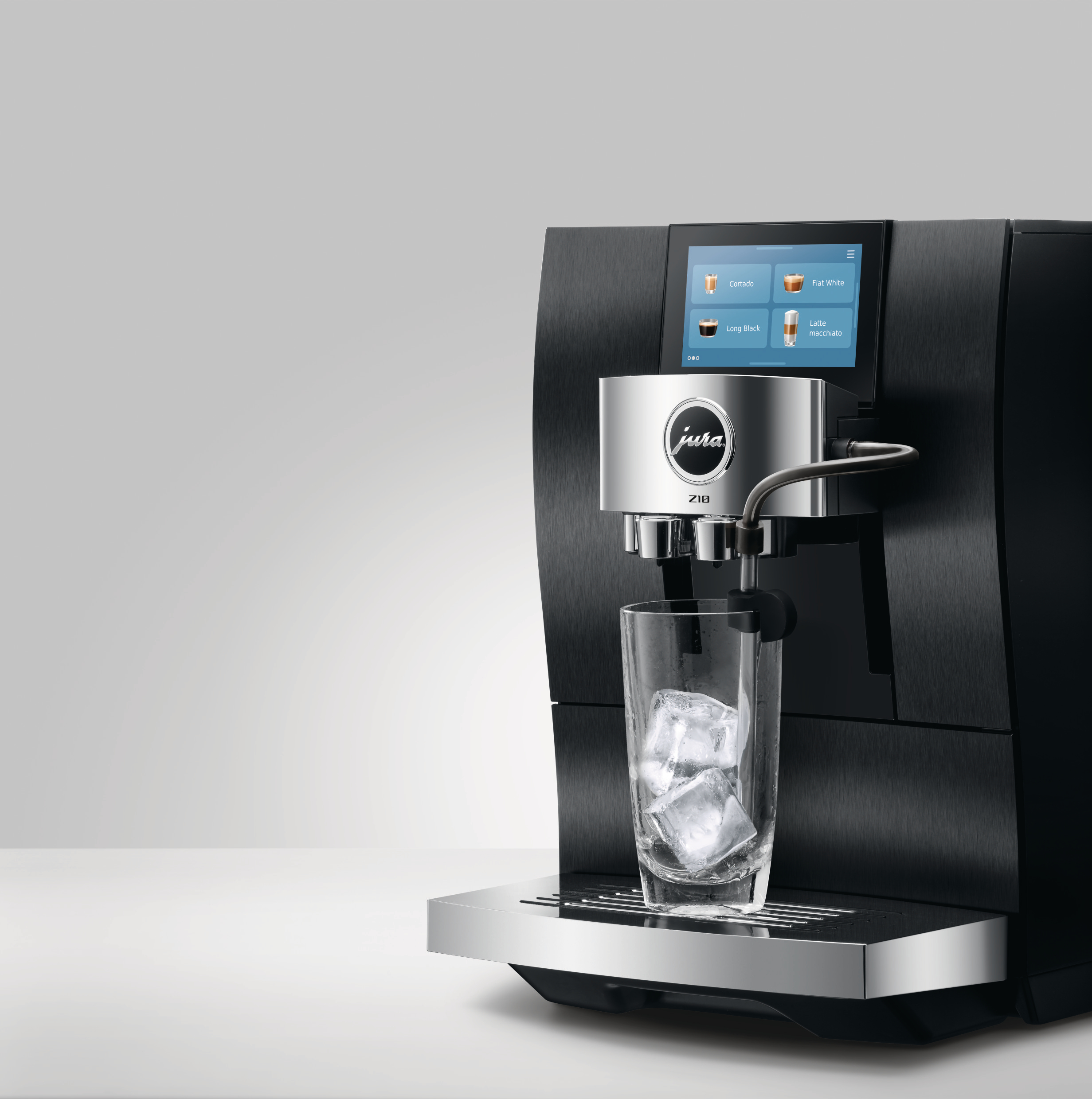 Eine schwarze Jura Z10 Kaffeemaschine mit Touchscreen, einem Glas mit Eiswürfeln und einem weißen Hintergrund.