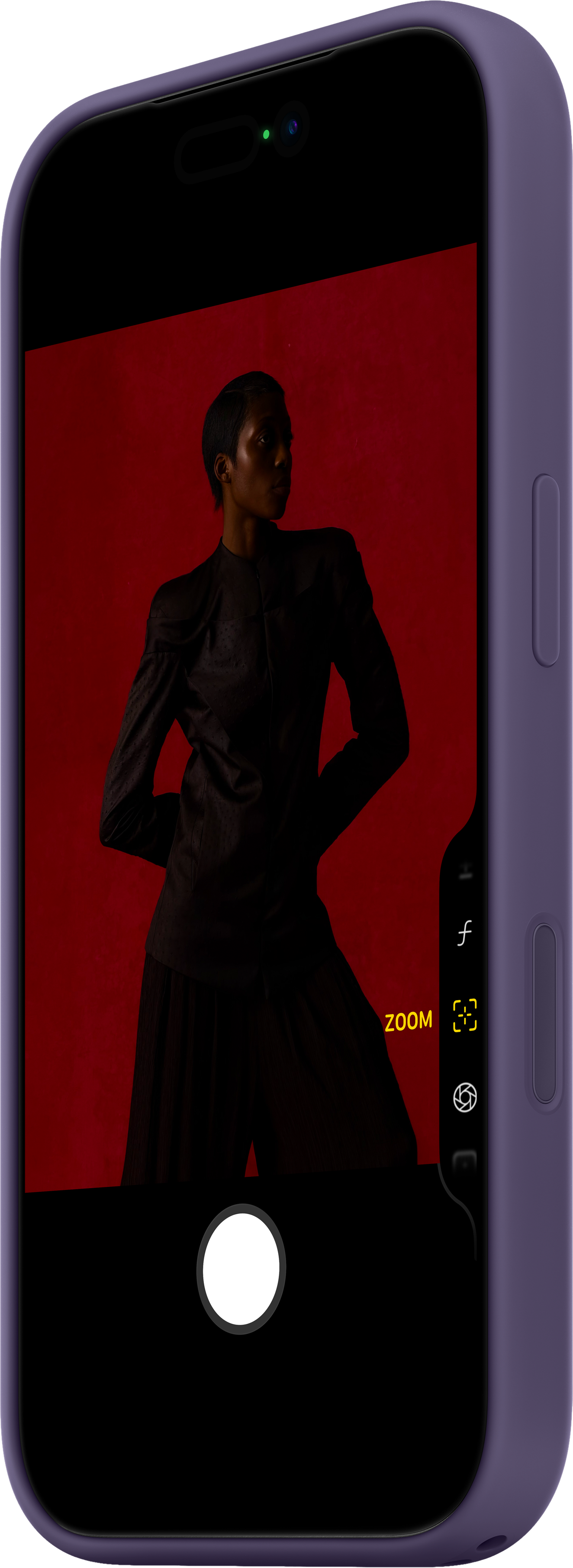 Un telefono mostra una persona vestita di scuro su sfondo rosso. Il telefono ha una custodia viola con funzioni fotocamera.