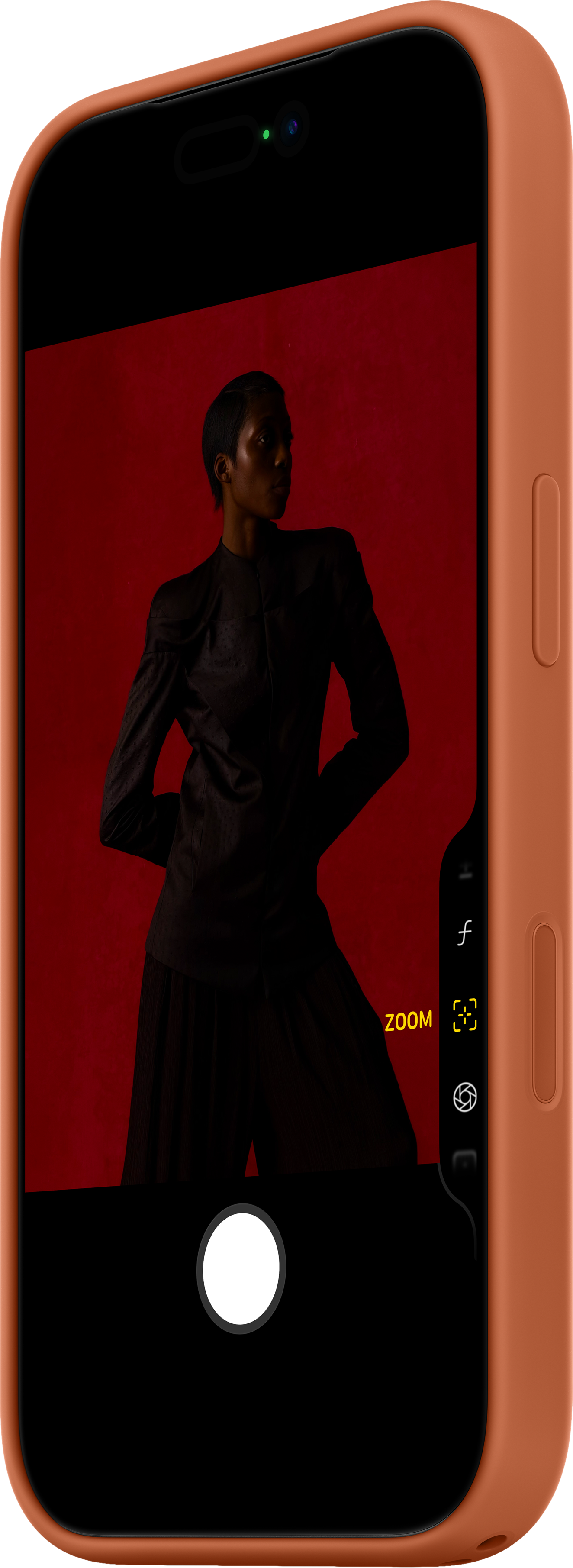 Un telefono mostra una donna vestita di scuro su sfondo rosso. Il telefono è arancione.