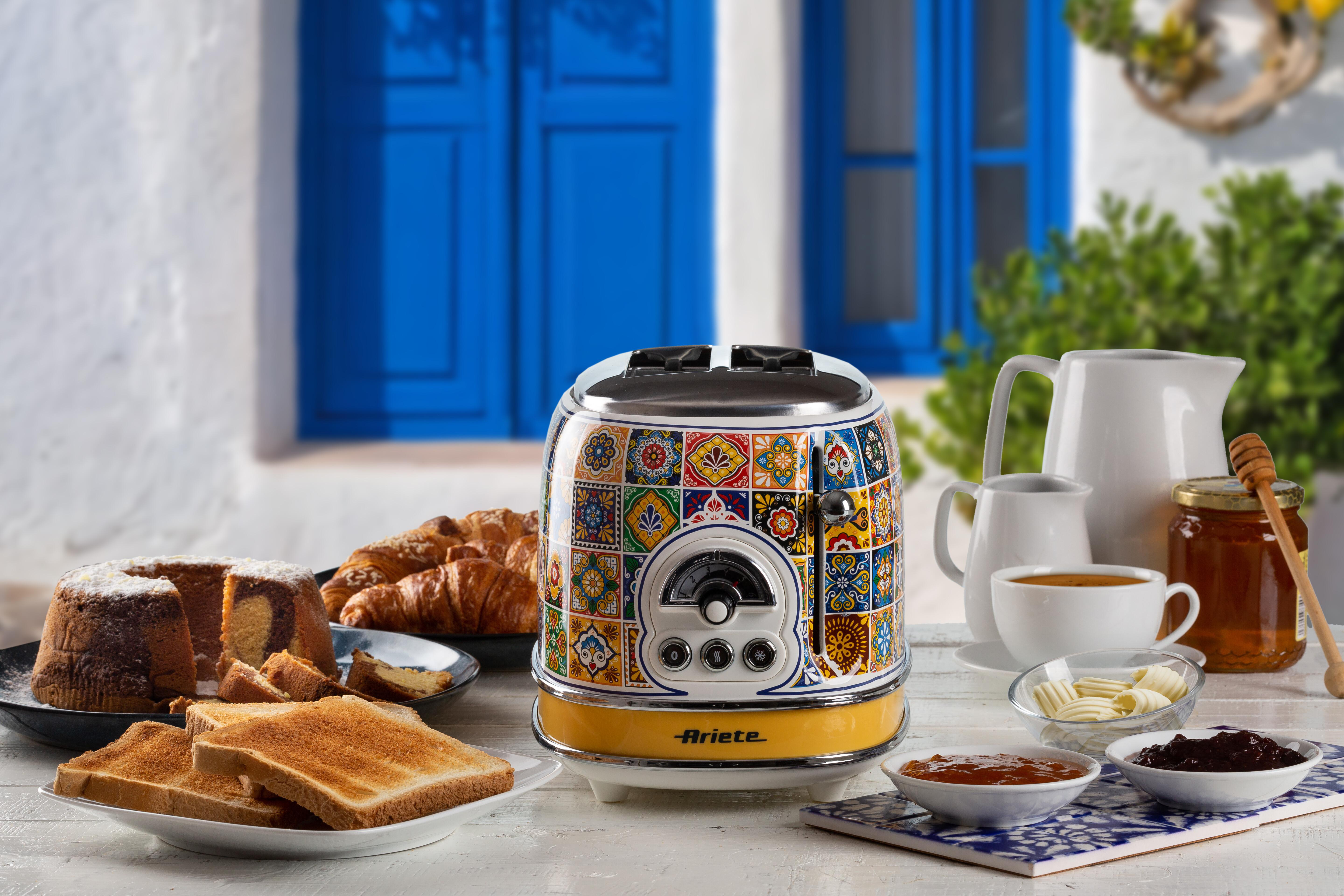 Frühstücksszene mit Toaster, Toast, Kuchen, Croissants, Kaffee und Marmeladen. Blaue Tür im Hintergrund.