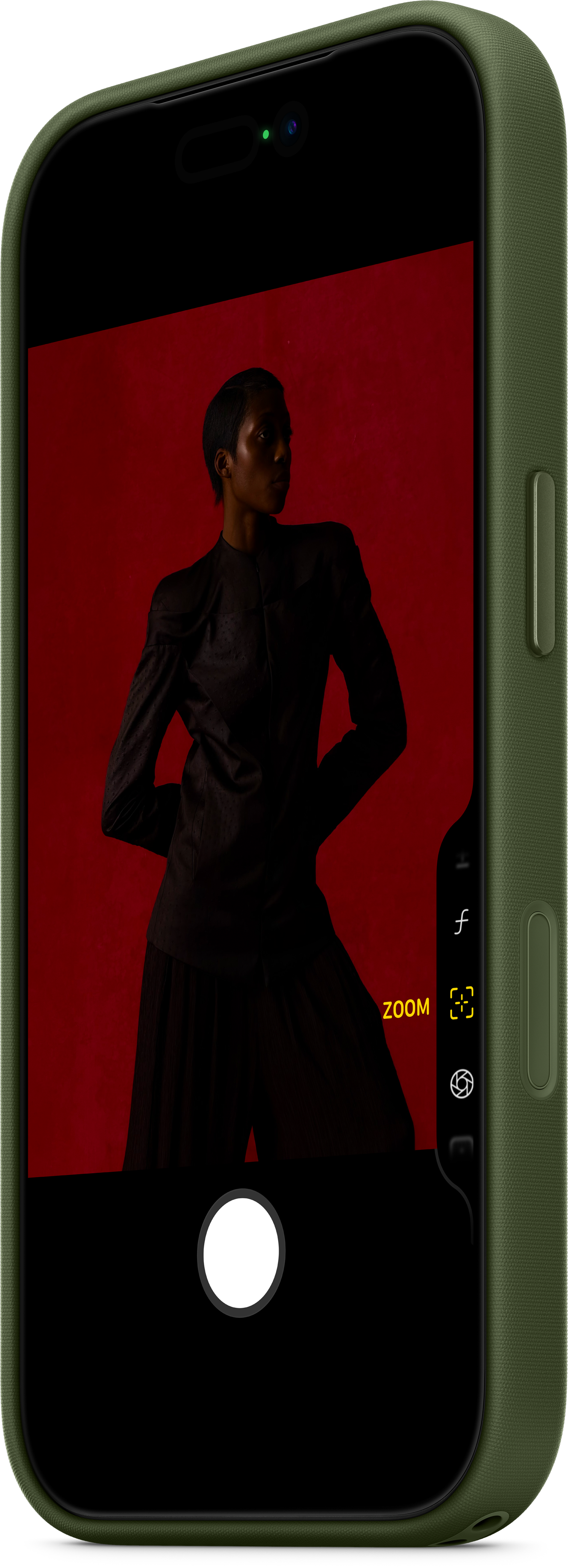 Un téléphone affiche une personne en costume noir. Le fond est rouge. Le téléphone est dans une coque verte.