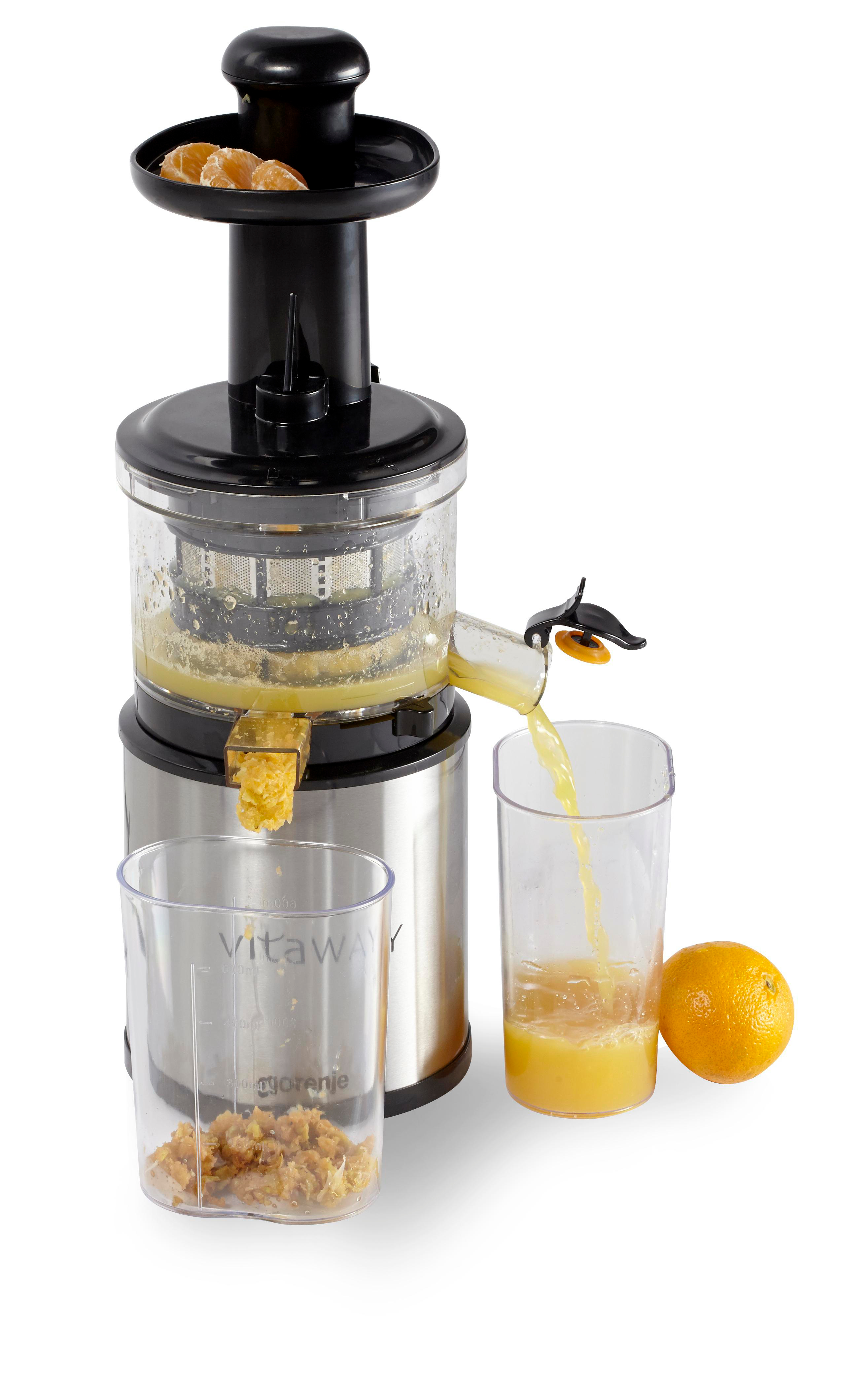 Eine Saftpresse mit einem klaren Glas, Orangensaft, Orange und Fruchtfleisch. Orangenstücke liegen oben. Saft wird gegossen.