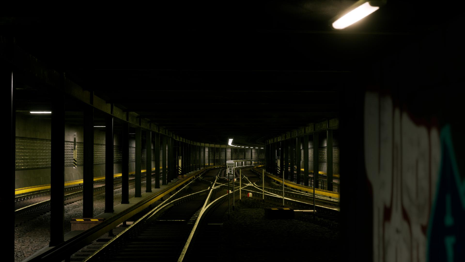 Dunkler U-Bahn-Tunnel mit mehreren Gleisen, gelben Sicherheitslinien und Graffiti rechts.