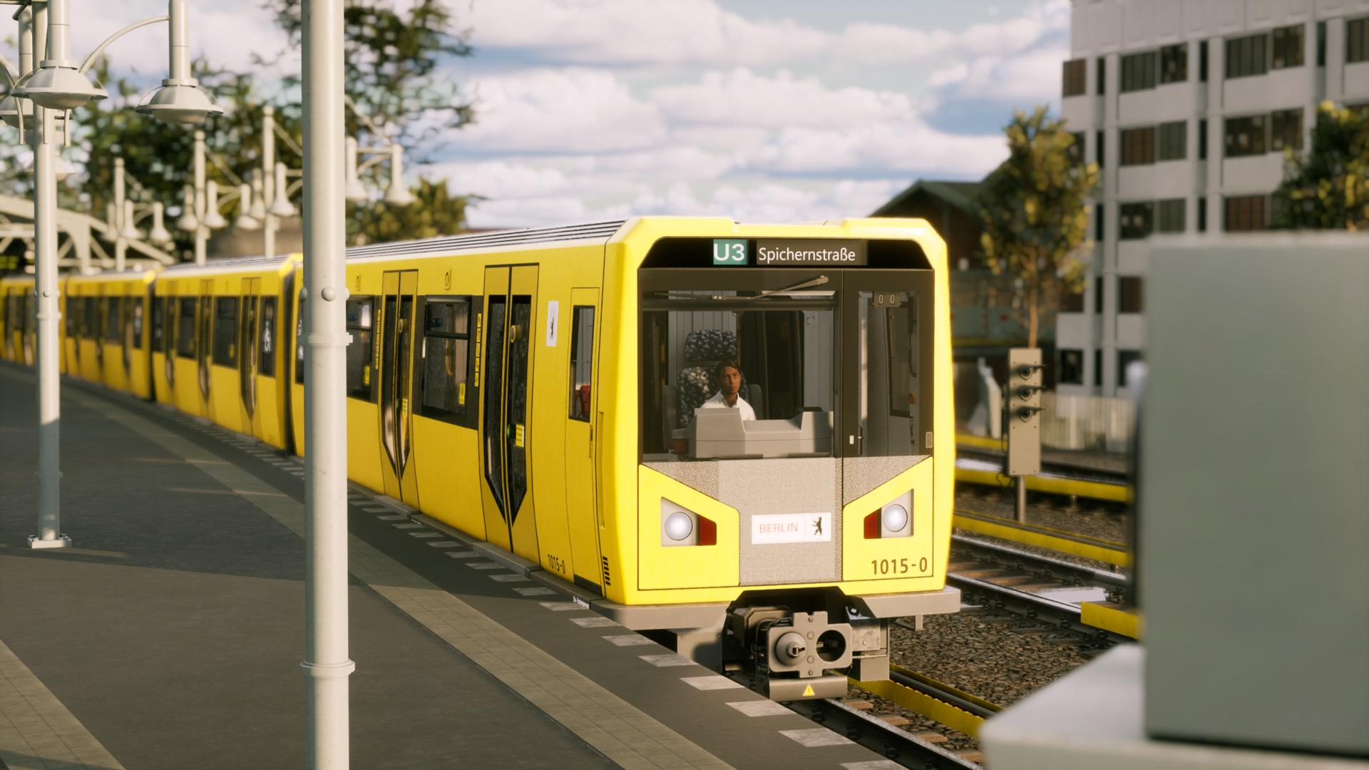 Ein gelber U-Bahn-Zug fährt auf einem Bahnsteig. Ein Fahrer sitzt im Führerhaus.