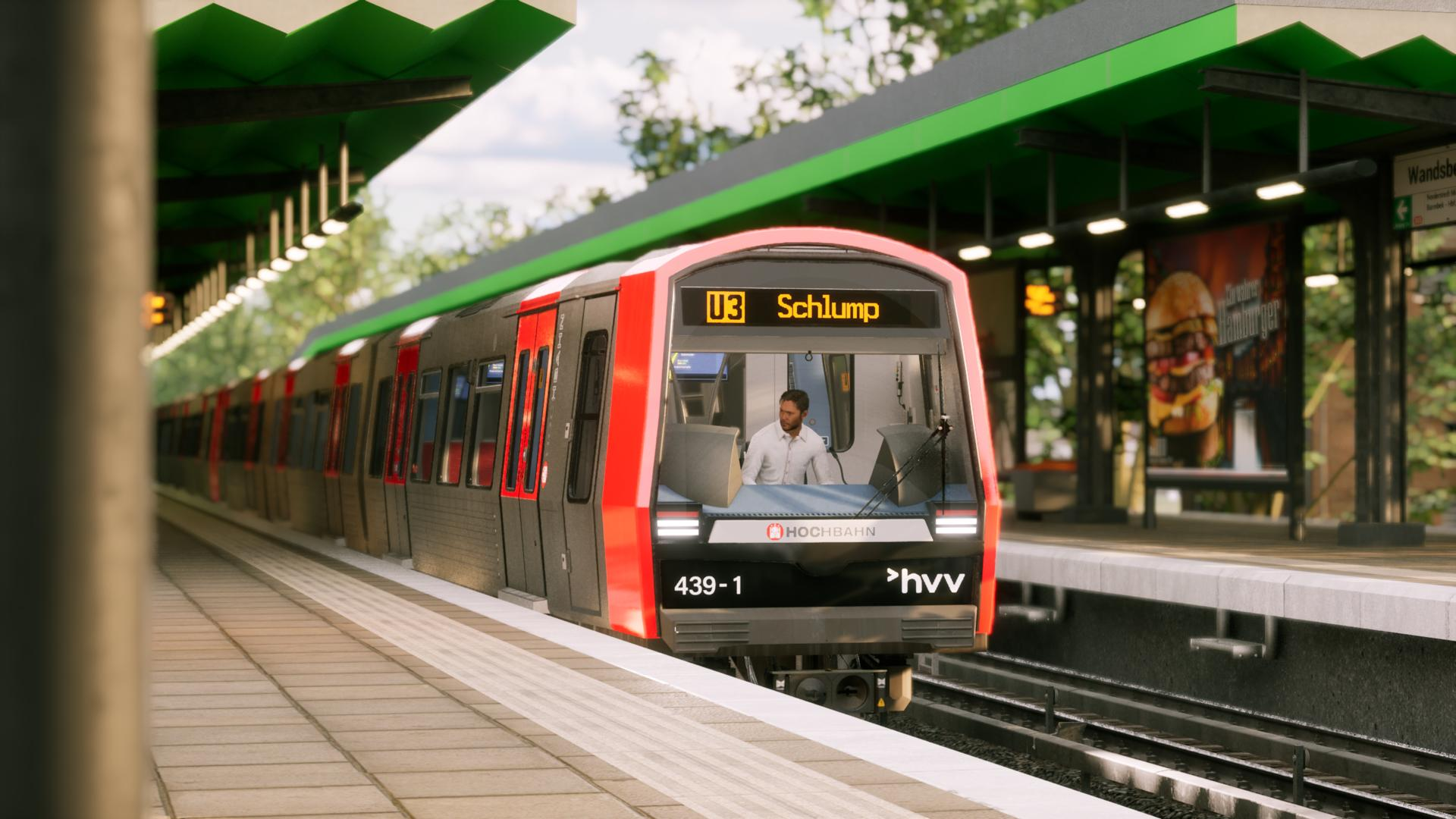 Ein roter und grauer Zug steht auf einer Bahnsteigkante. Ein Mann sitzt am Steuer.
