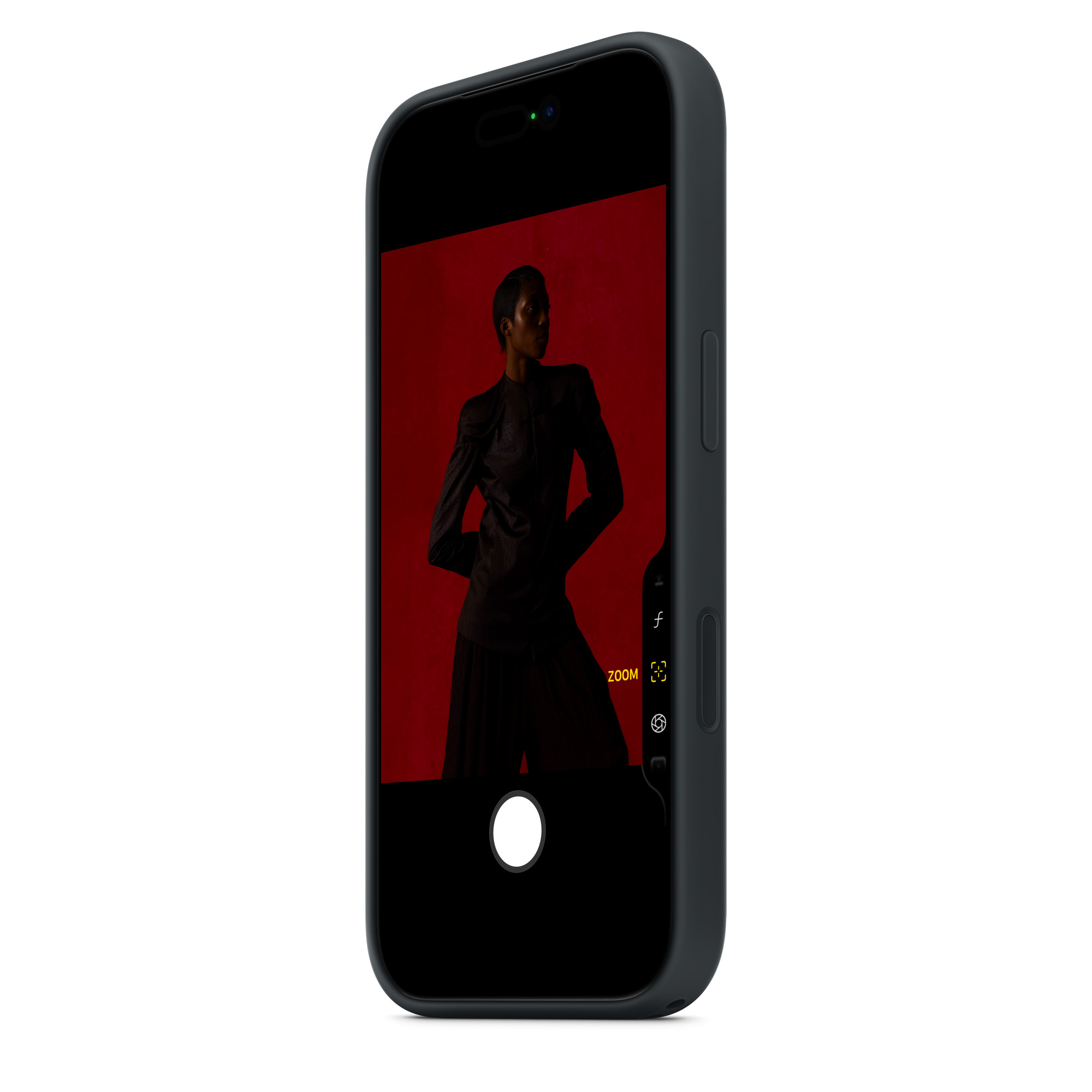 Egy telefon fekete ruhás személyt jelenít meg piros háttér előtt. A telefon fekete, fehér háttérrel.