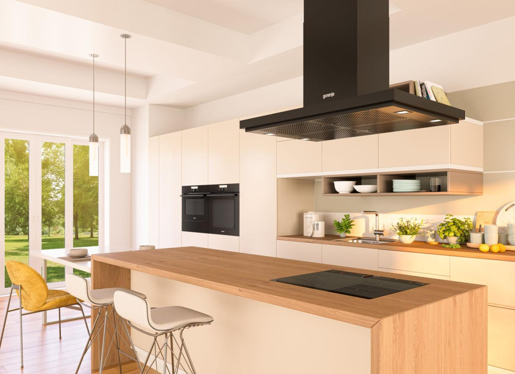 Nowoczesna kuchnia z wyspą, czarnym okapem i urządzeniami. Słoneczny widok przez duże okna. Hoker i żółte krzesło obecne.