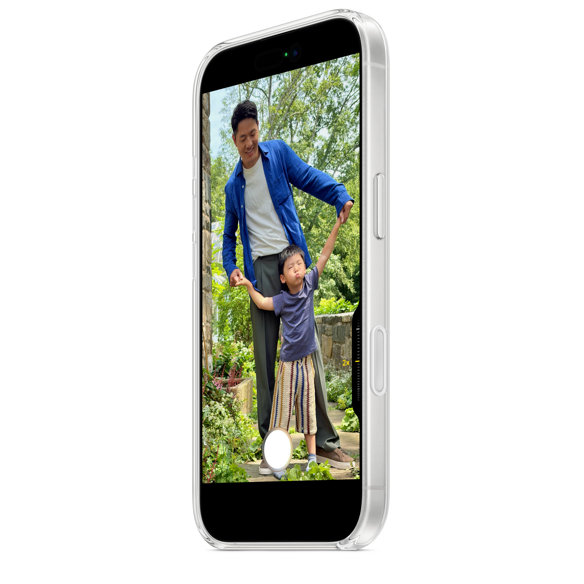 Egy férfi és egy gyerek a kertben vannak. Kezet fognak, a gyerek karjai fel vannak emelve. A fotó egy telefon képernyőjén látható.