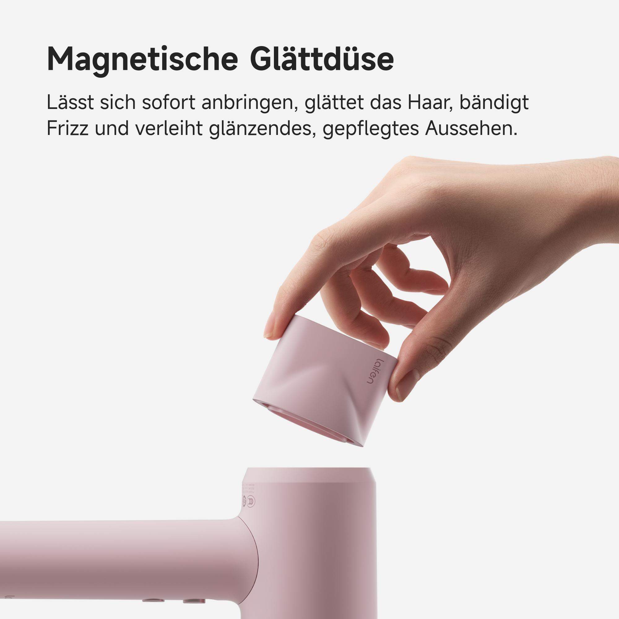 Eine Hand hält einen rosafarbenen Aufsatz für einen Haartrockner. Darüber steht: 'Magnetische Glättdüse'.