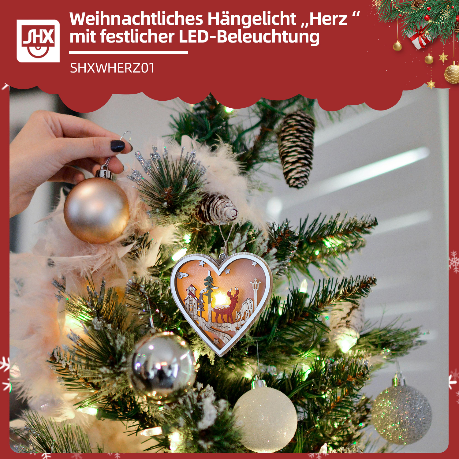 Eine Hand hält eine goldene Kugel an einem geschmückten Weihnachtsbaum mit herzförmigem Licht und verschiedenen Ornamenten.