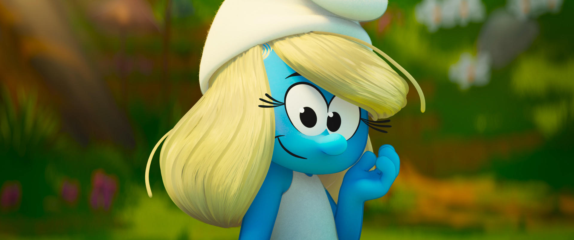 Schlumpfine, ein blauer Cartoon-Charakter mit blonden Haaren und einem weißen Hut, lächelt den Betrachter an. Der Hintergrund ist grün und unscharf.