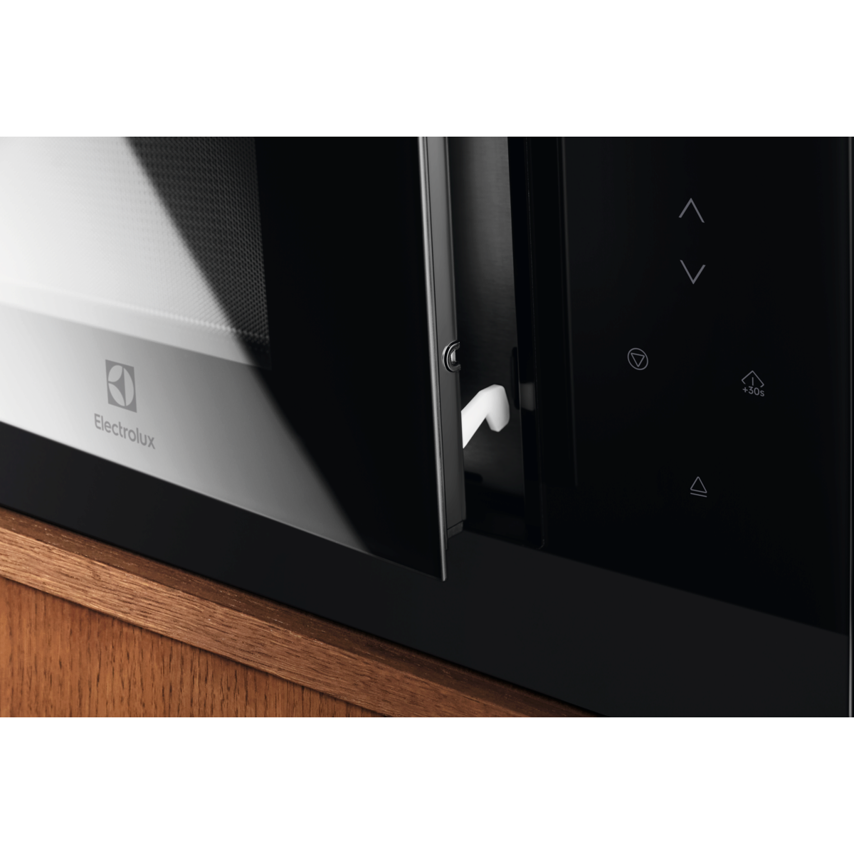 Egy fekete mikrohullámú sütő, félig nyitott ajtóval, Electrolux logóval. A vezérlőpanel jobbra található.