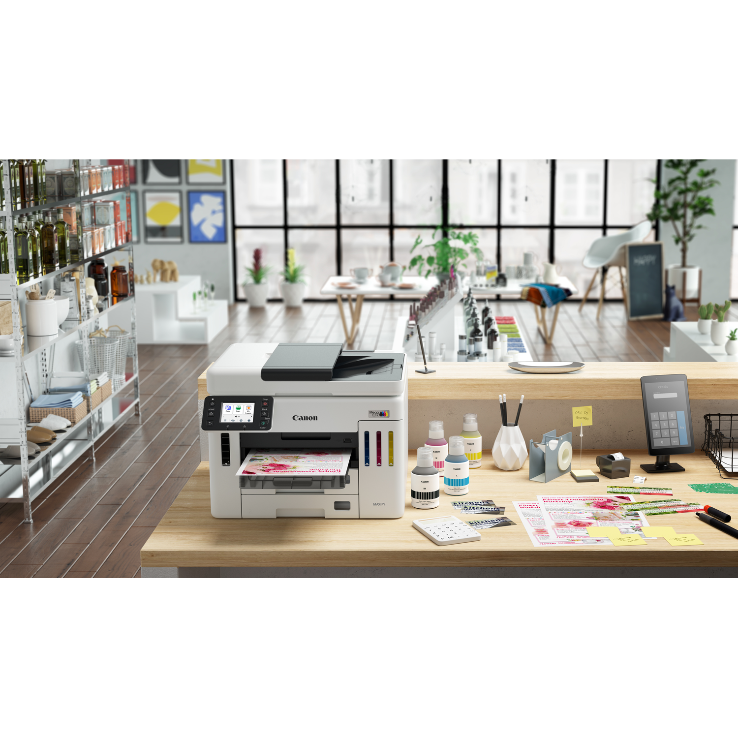 A Canon printer sits on a wooden counter. Ink bottles, a calculator, and documents are on the counter. Background includes a shop.