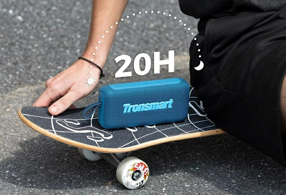 Osoba trzyma deskorolkę z niebieskim głośnikiem Tronsmart. Obraz pokazuje 20H żywotności baterii.