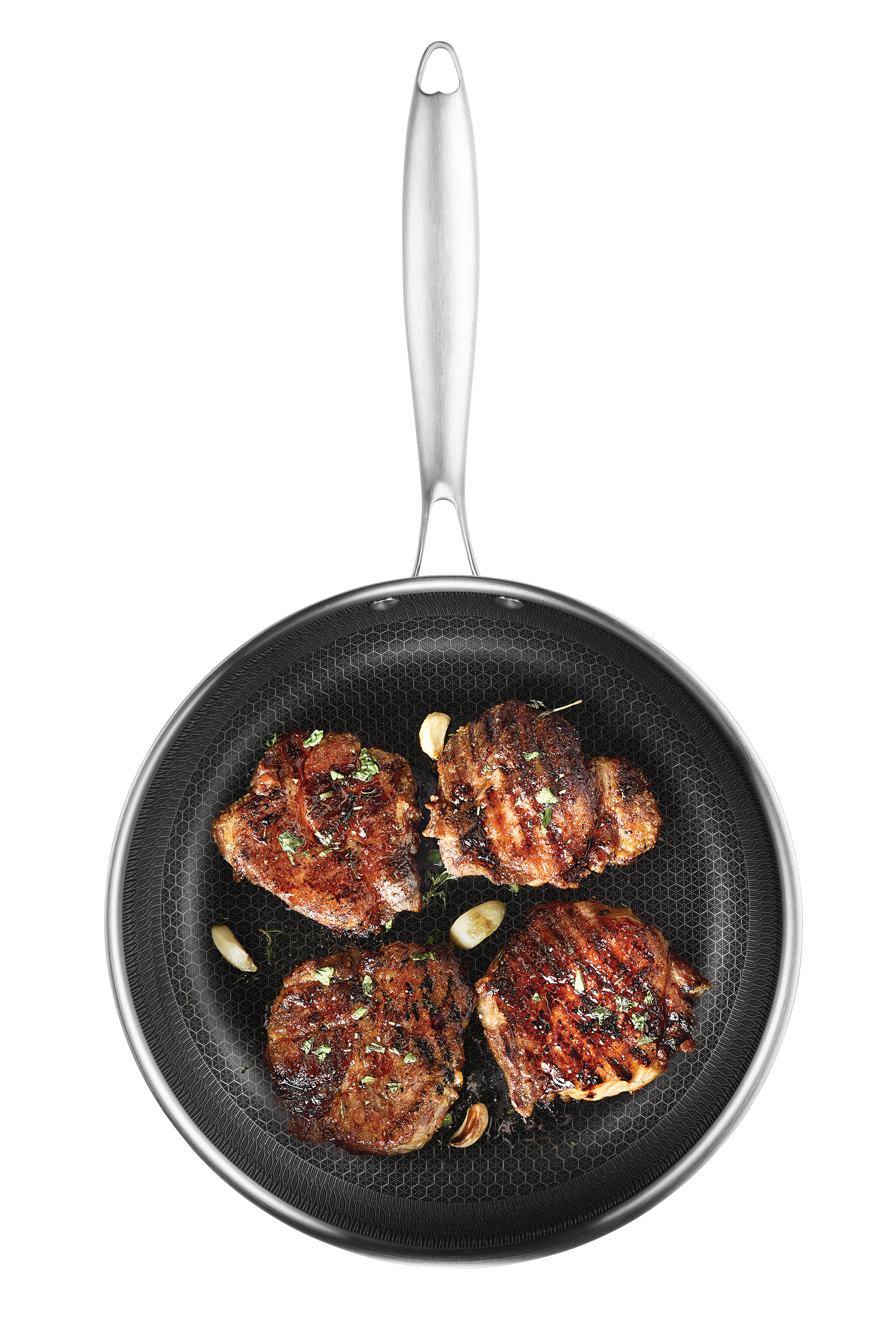 Vier gegrillte Steaks in einer Pfanne mit Knoblauch und Kräutern, von oben gesehen. Die Pfanne hat einen silbernen Griff und steht auf weißem Grund.