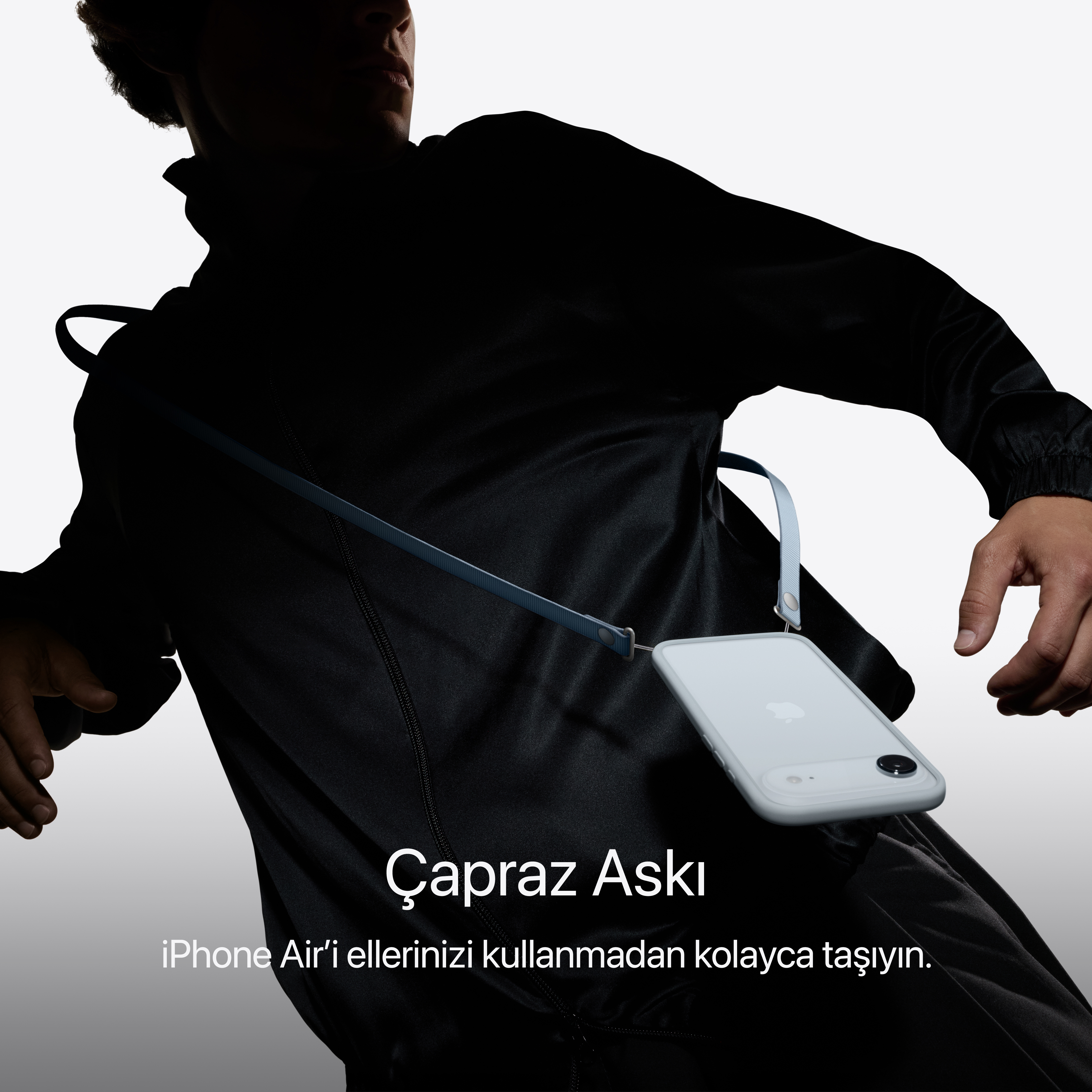Boynunda telefon kılıfı olan siyah ceketli bir kişi. Telefon beyaz renktedir.