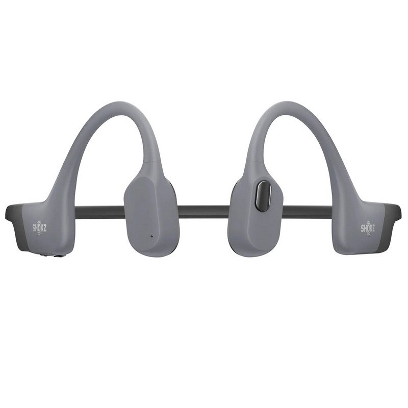 Auriculares Shokz grises. El diseño presenta una diadema arqueada. Las almohadillas son redondeadas y están conectadas por una barra negra.