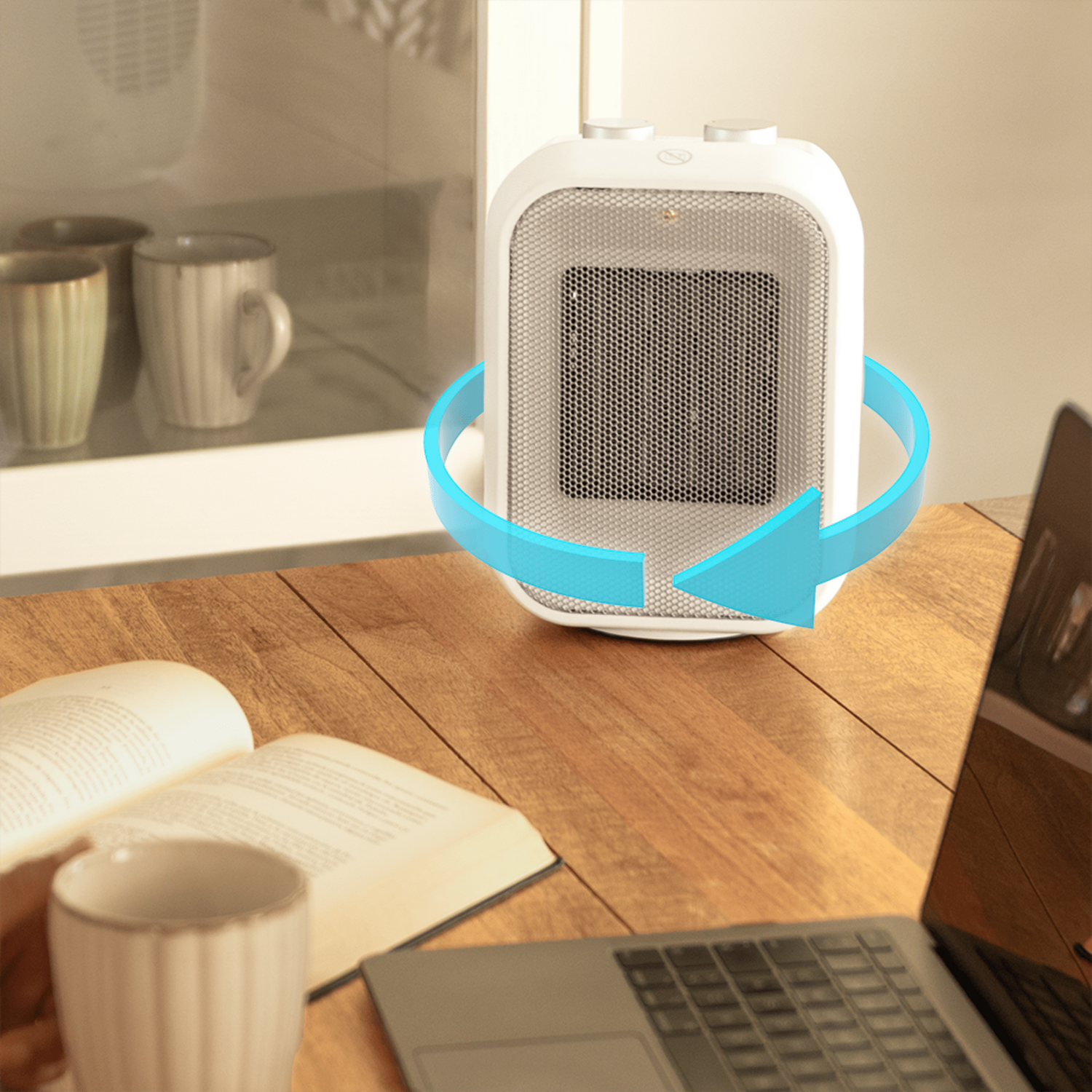 Un calentador blanco con una flecha azul, libro, taza y portátil sobre una mesa de madera. Fondo con tazas y ventana.