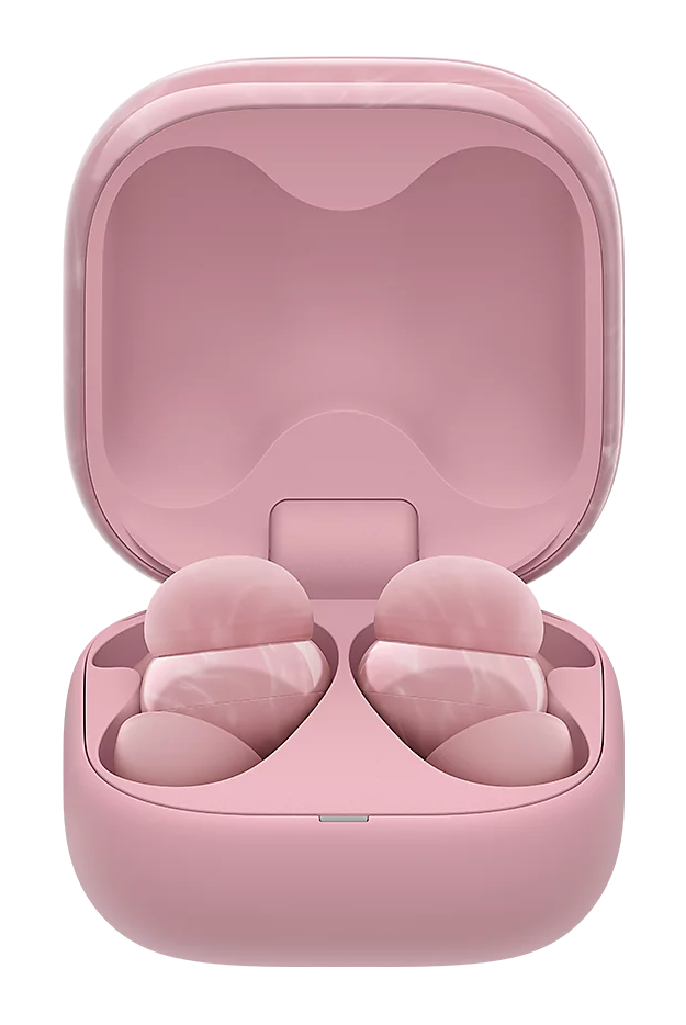 Otwarty różowy futerał na słuchawki douszne ujawnia dwie słuchawki. Etui i słuchawki są w pasującym odcieniu różu na czarnym tle.
