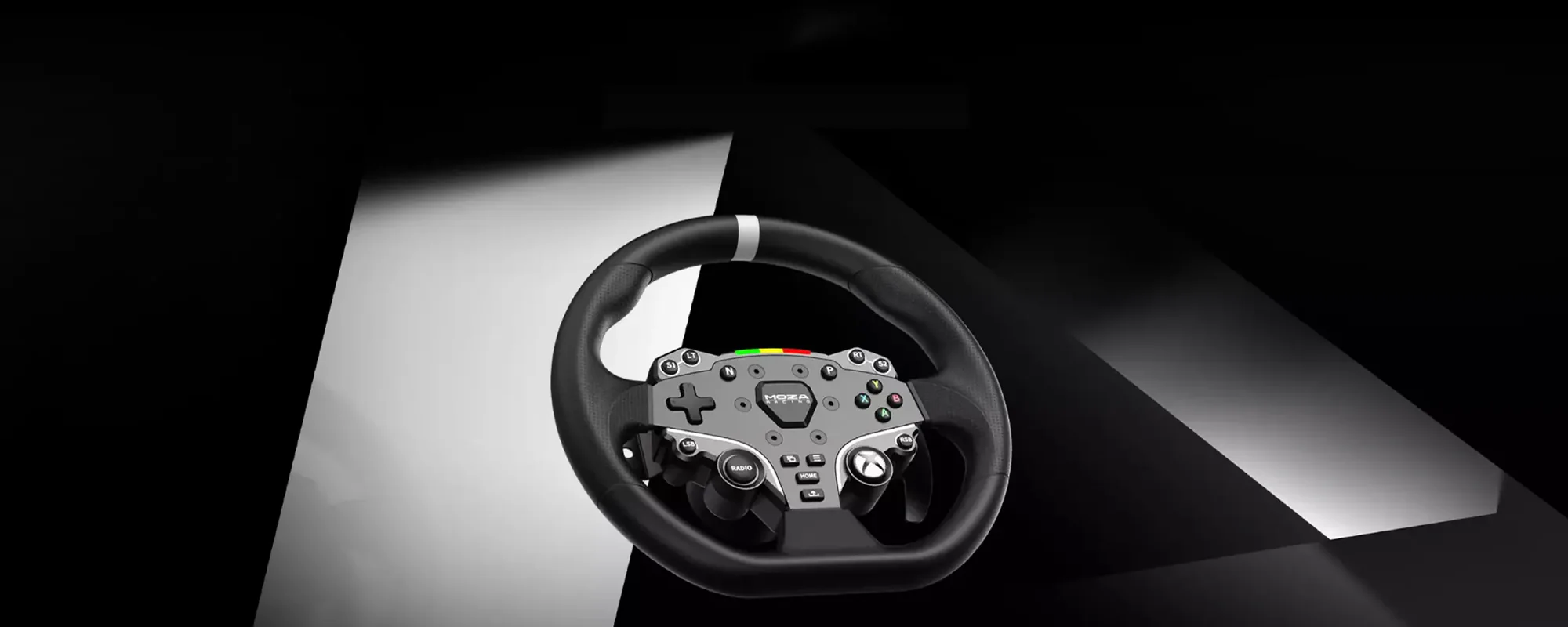 Ein Gaming-Lenkrad mit schwarzem Griff, silbernen Akzenten und einem Bedienfeld, vor einem schwarz-weißen Hintergrund.
